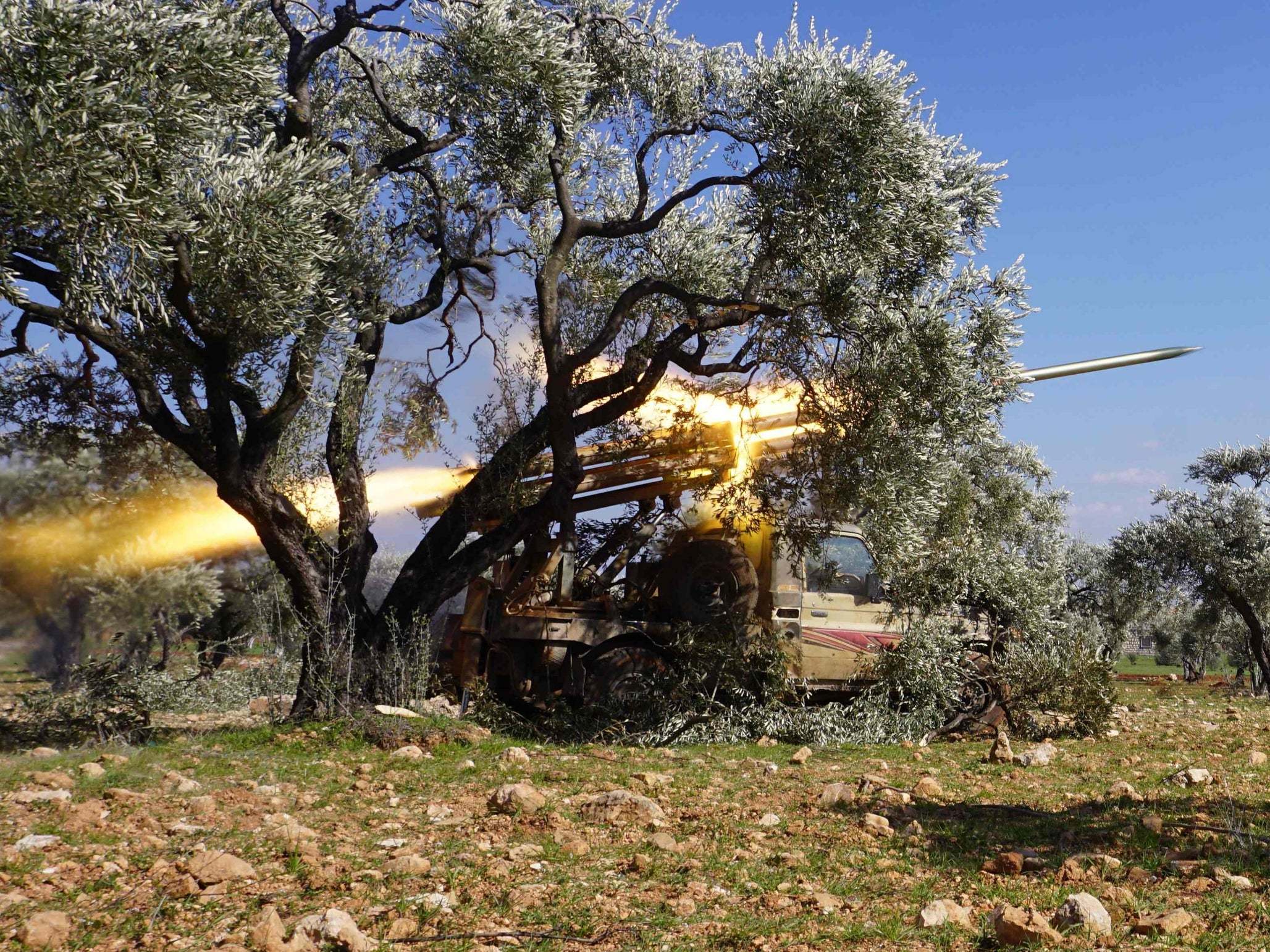 Members of Syria's opposition National Liberation Front remotely-fire a rocket at a position near the village of al-Nayrab