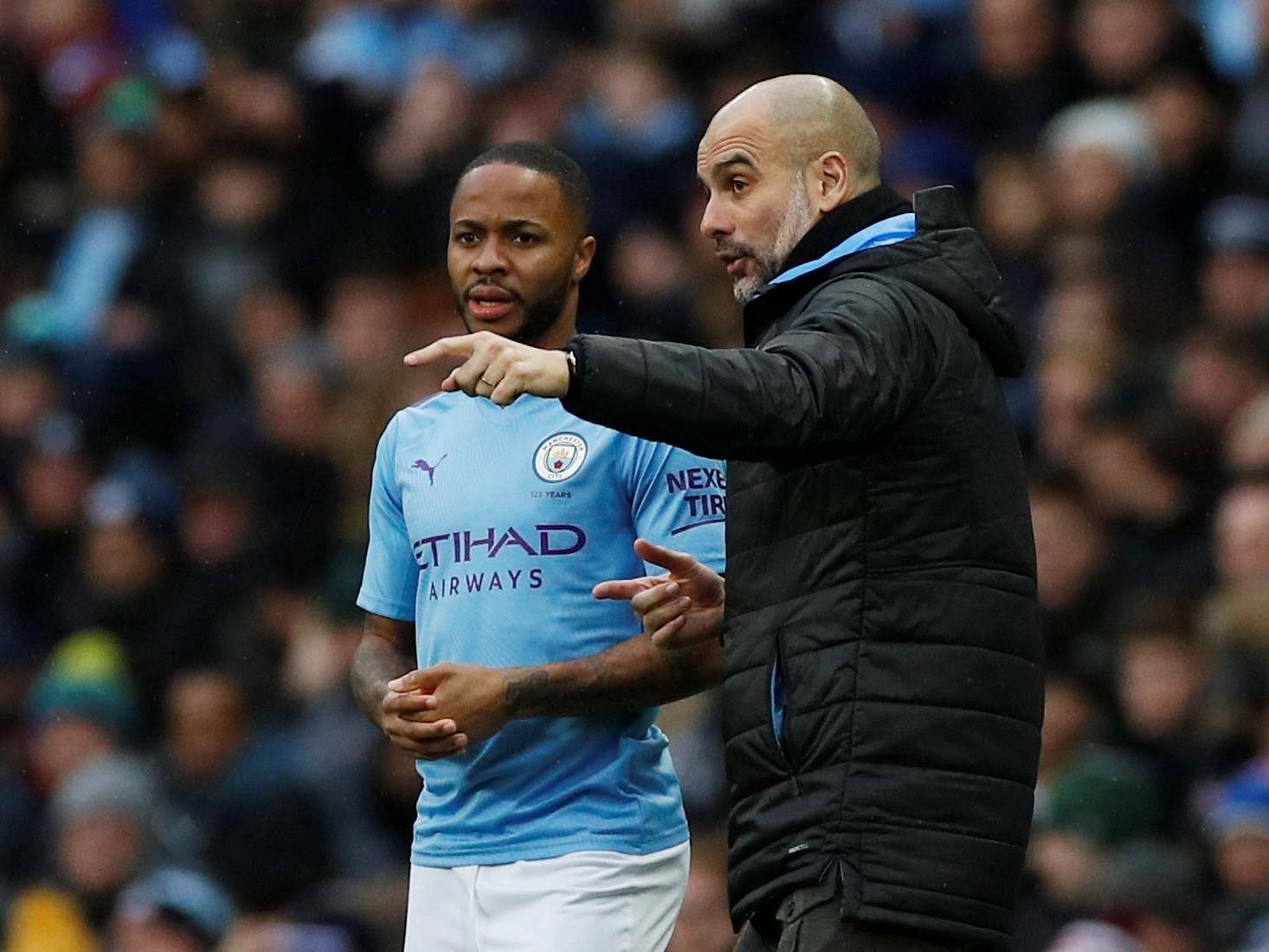 Manchester City's Raheem Sterling receives instructions from manager Pep Guardiola