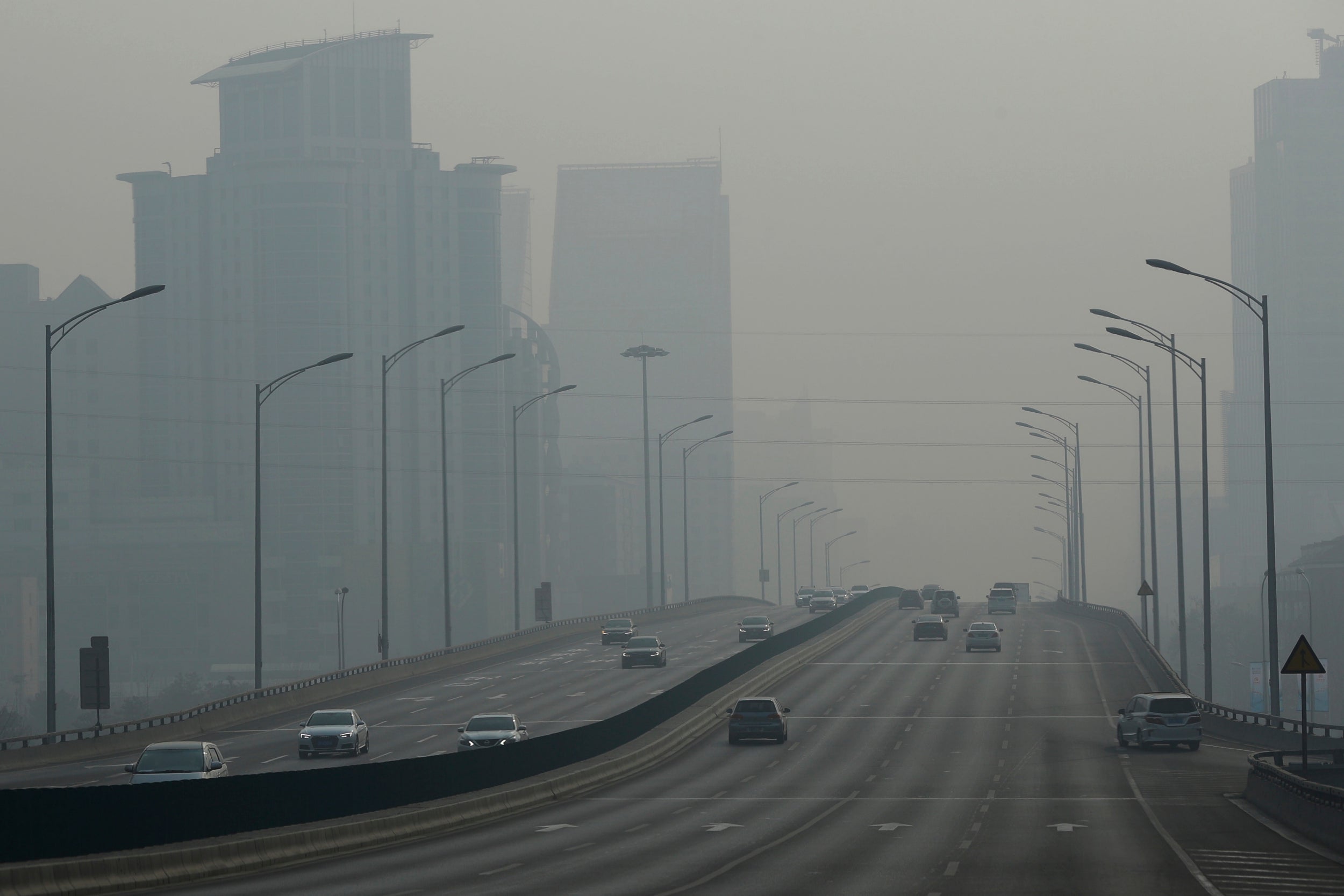 Vehicles travel on a main road as air pollution reduces visability in Beijing