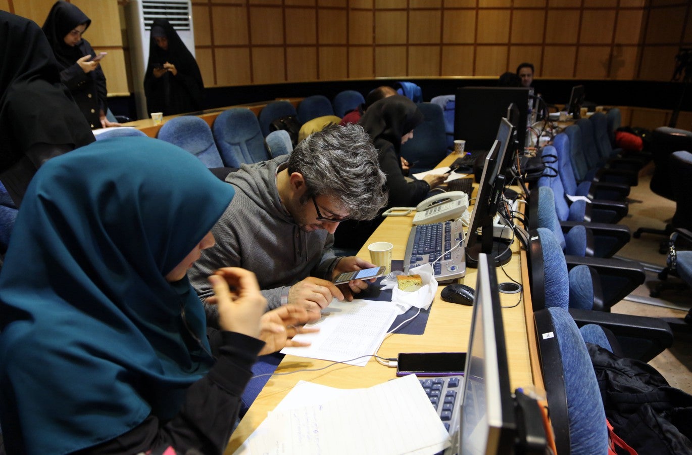 Press members follow the election results as vote counting for the 11th parliamentary elections continue in Tehran (Getty)