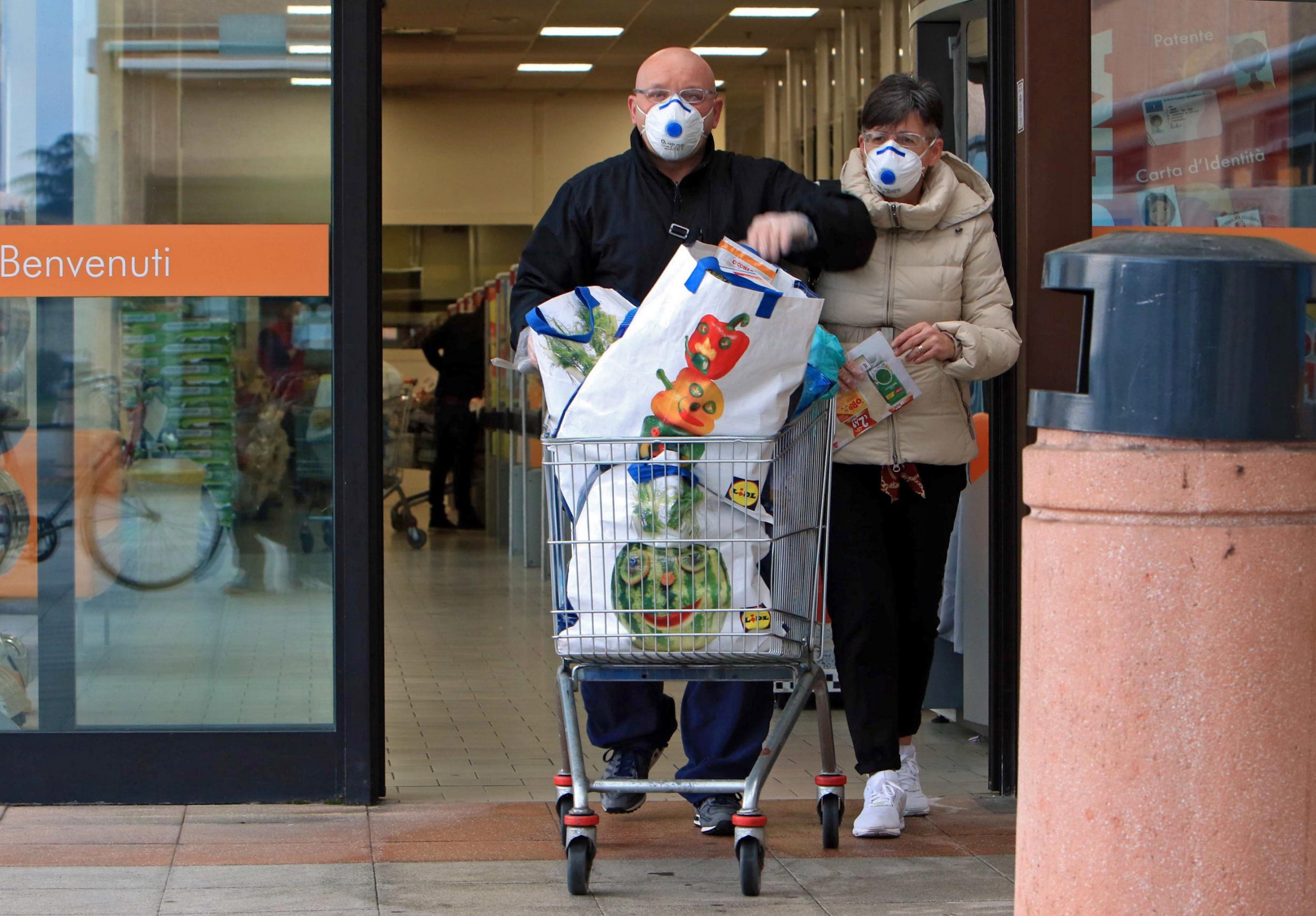 People wearing protective face masks shop at a supermarket in Casalpusterlengo, one the northern Italian towns placed under lockdown due to the new coronavirus outbreak