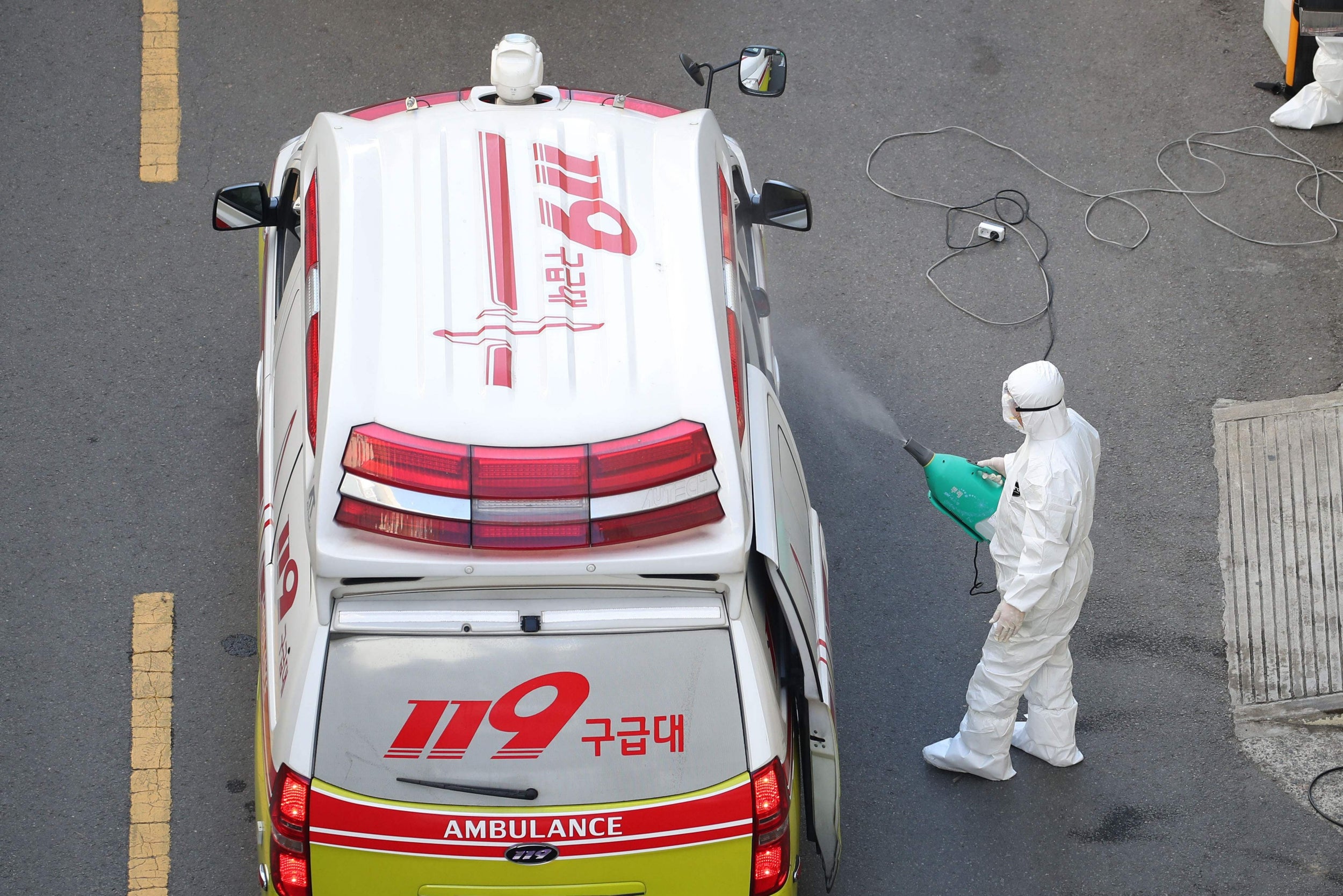 A medical worker sprays disinfectant on an ambulance after carrying a patient infected with the COVID-19 coronavirus at a hospital in Daegu