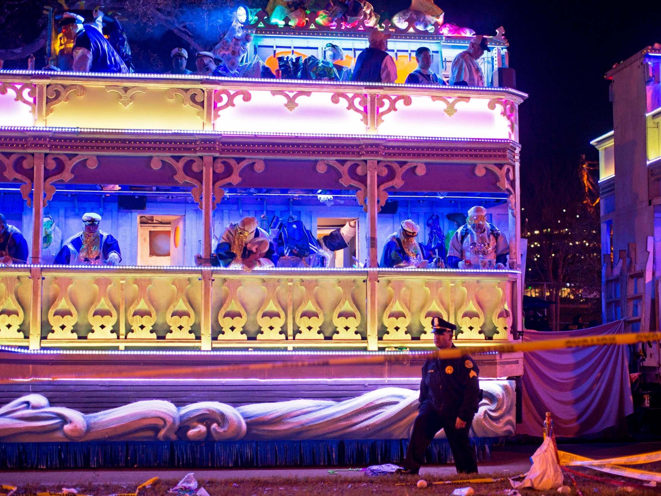 A police officer works the scene where a man was reportedly hit and killed by a float of the Krewe of Endymion parade in the runup to Mardi Gras