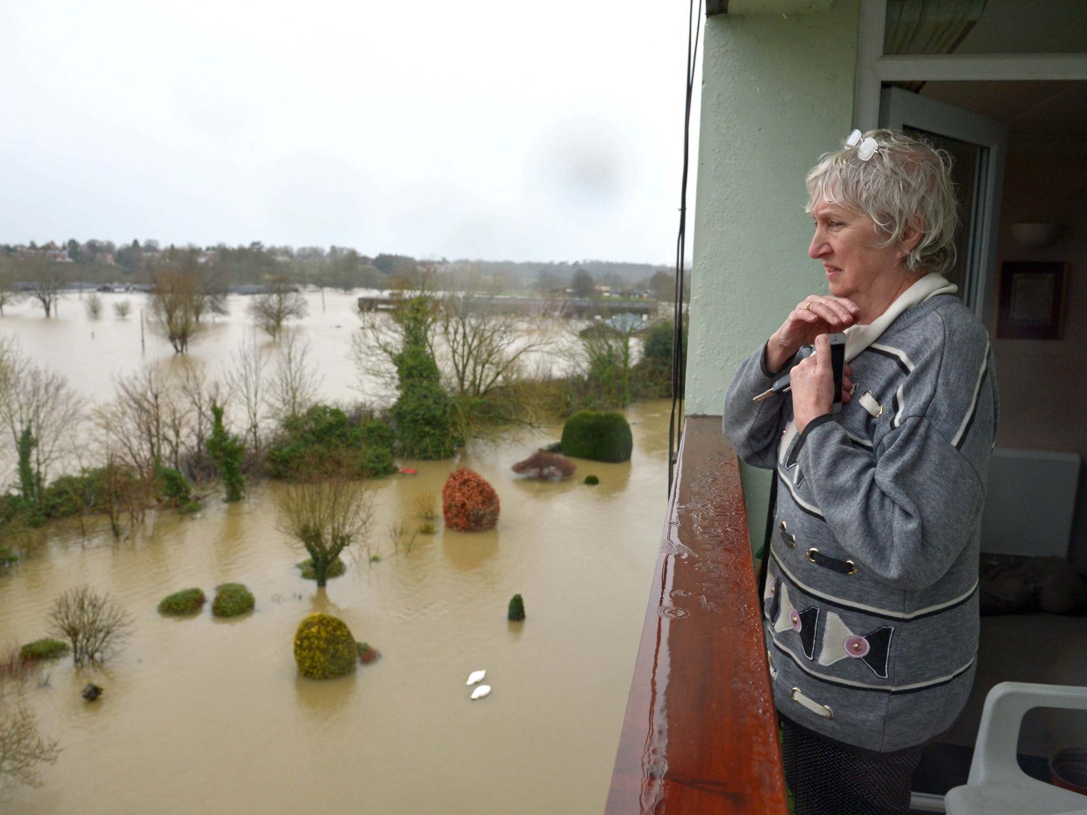 A resident living in a flat near the River Severn in Shrewsbury looks out over flooded gardens