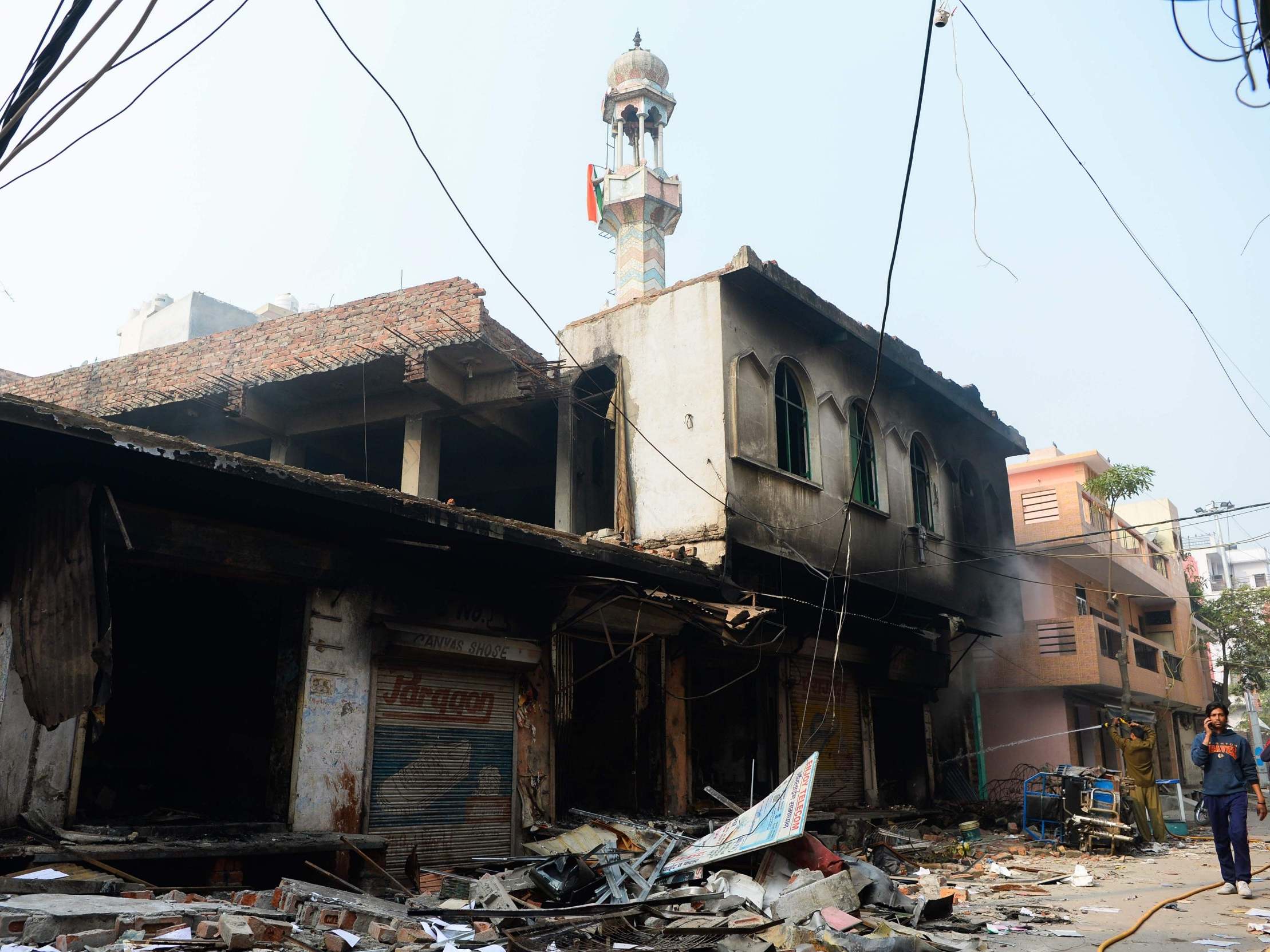 Flags can be seen on the burnt-out mosque’s minaret in the Ashok Nagar neighbourhood