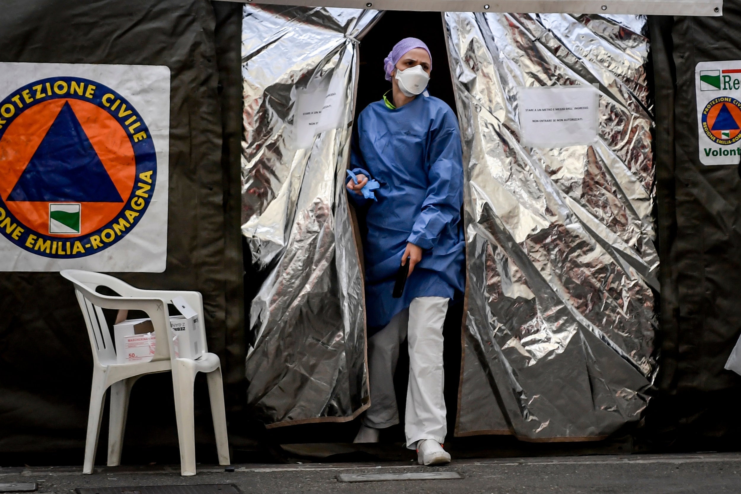 Paramedic treats patients in a tent set up by the Italian Civil Protection outside the emergency ward of the Piacenza hospital, northern Italy