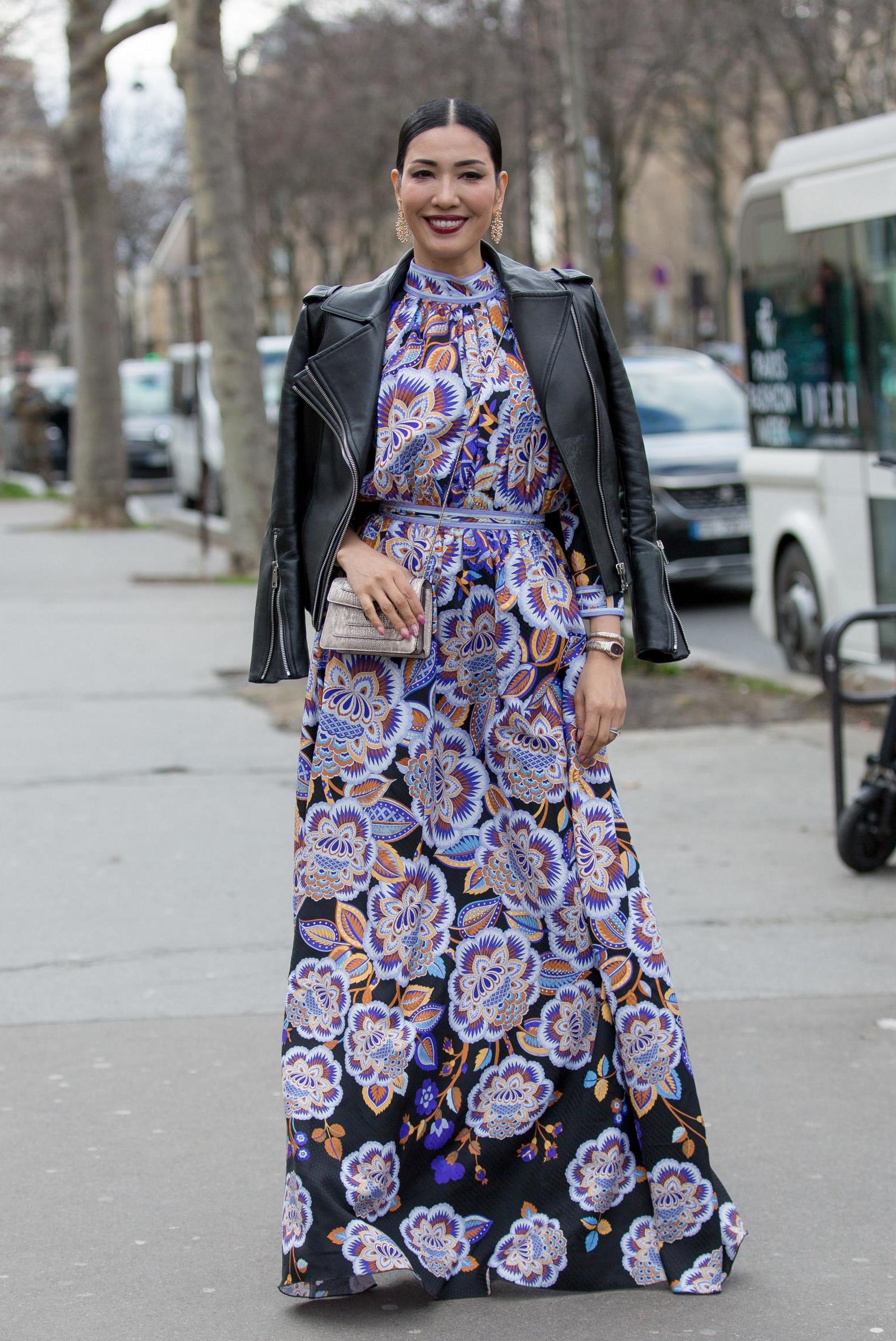This fashion week guest made a bold statement in a purple printed floor-length gown and leather jacket, carrying a small silver handbag.