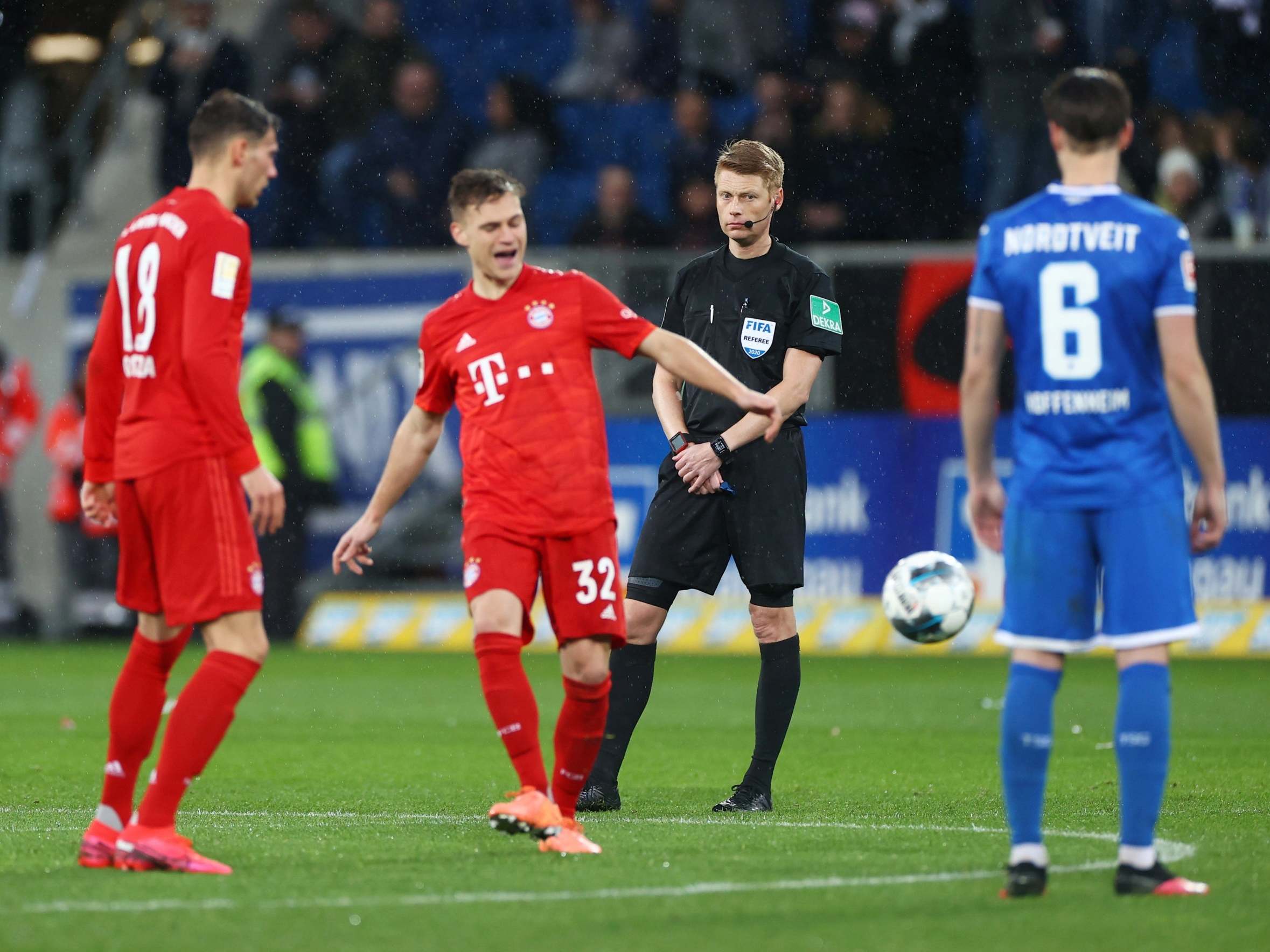 The referee looks on as players stop playing due to abusive chants