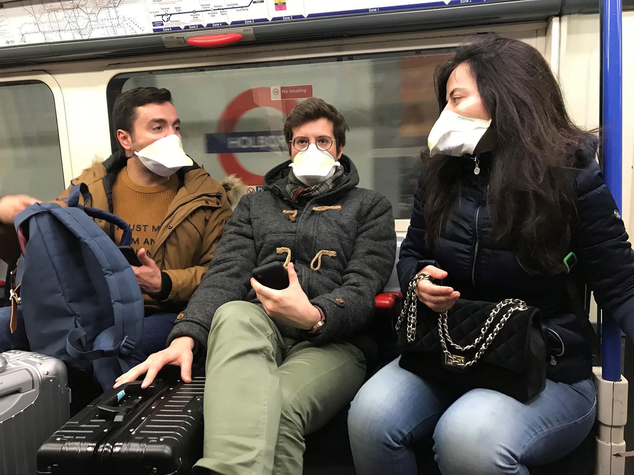 Commuters pictured wearing face masks on the London Underground