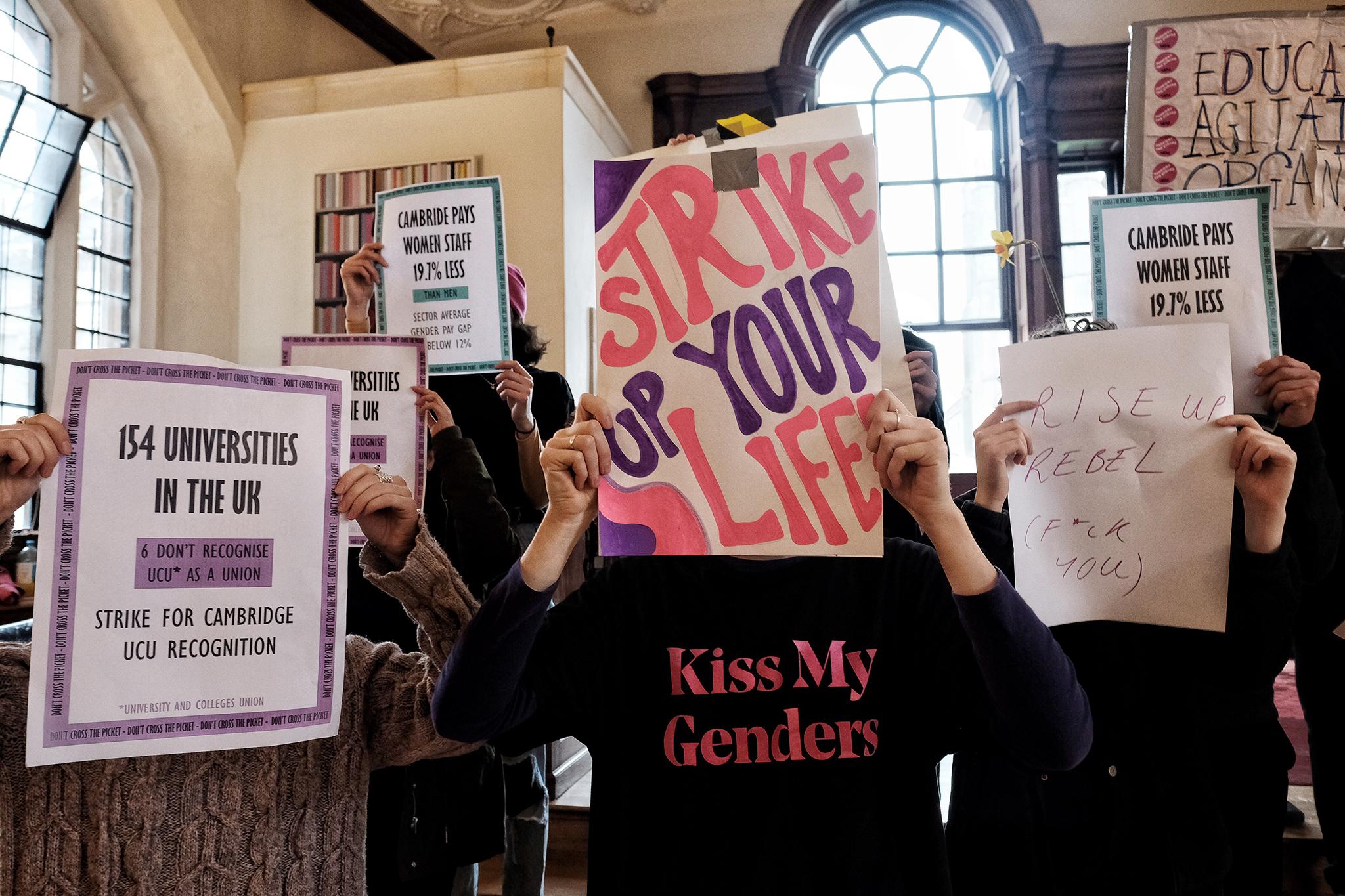 Inside the occupation, students hold up signs with their demands