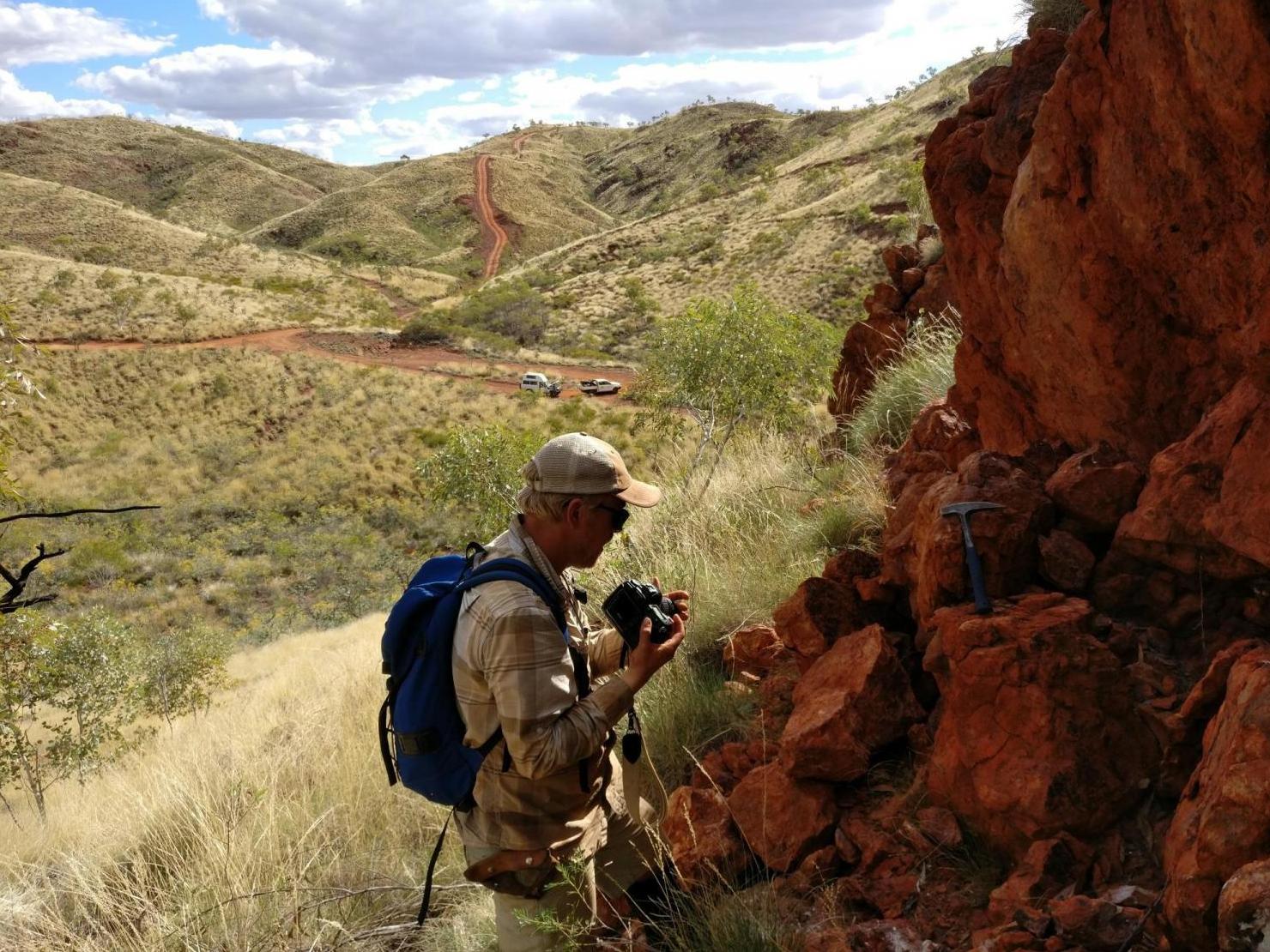 Lead author Benjamin Johnson inspects a rock outcrop near the site of an ancient hydrothermal vent in the Panorama district