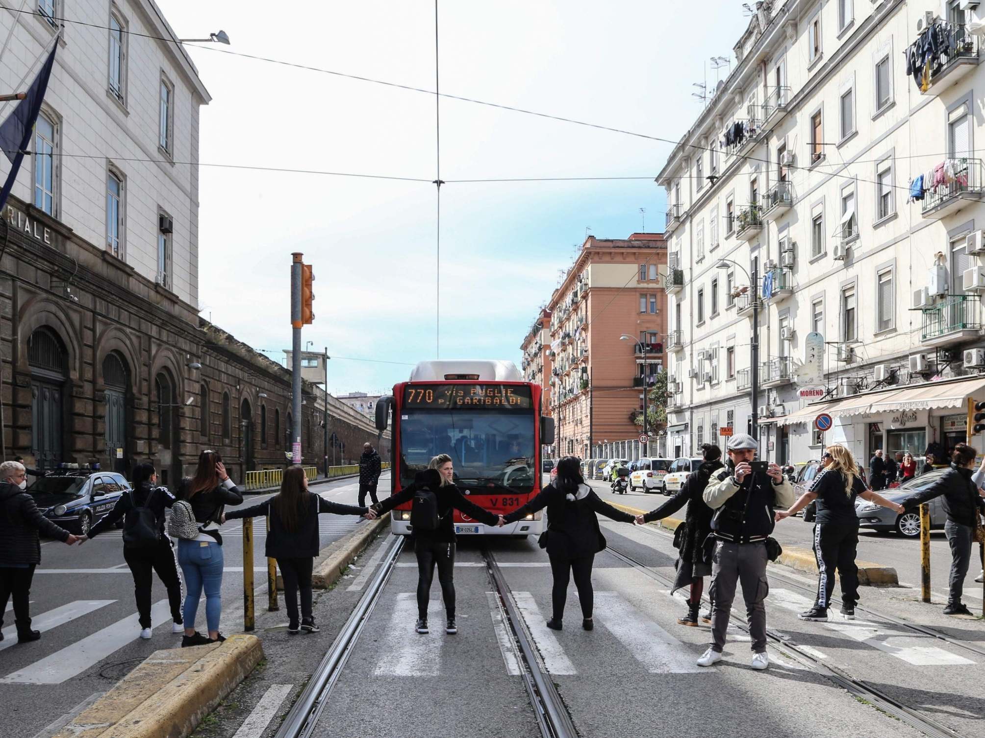 Inmates’ relatives form a human chain and block traffic to protest a ban on family visits, as part of new rules introduced to contain the coronavirus outbreak, outside the Poggioreale prison in Naples on Monday