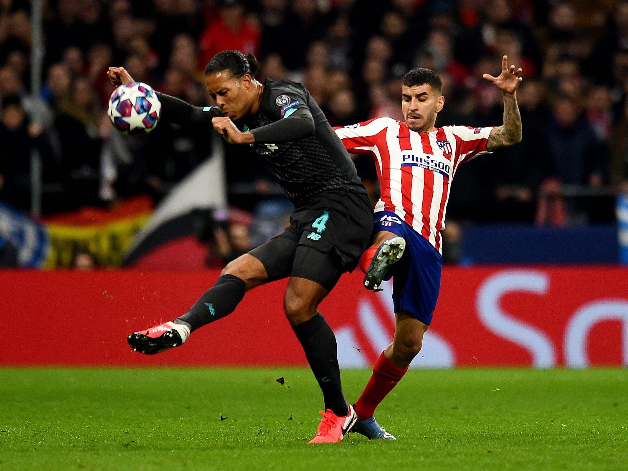 Virgil van Dijk of Liverpool competing with Angel Correa of Atletico Madrid