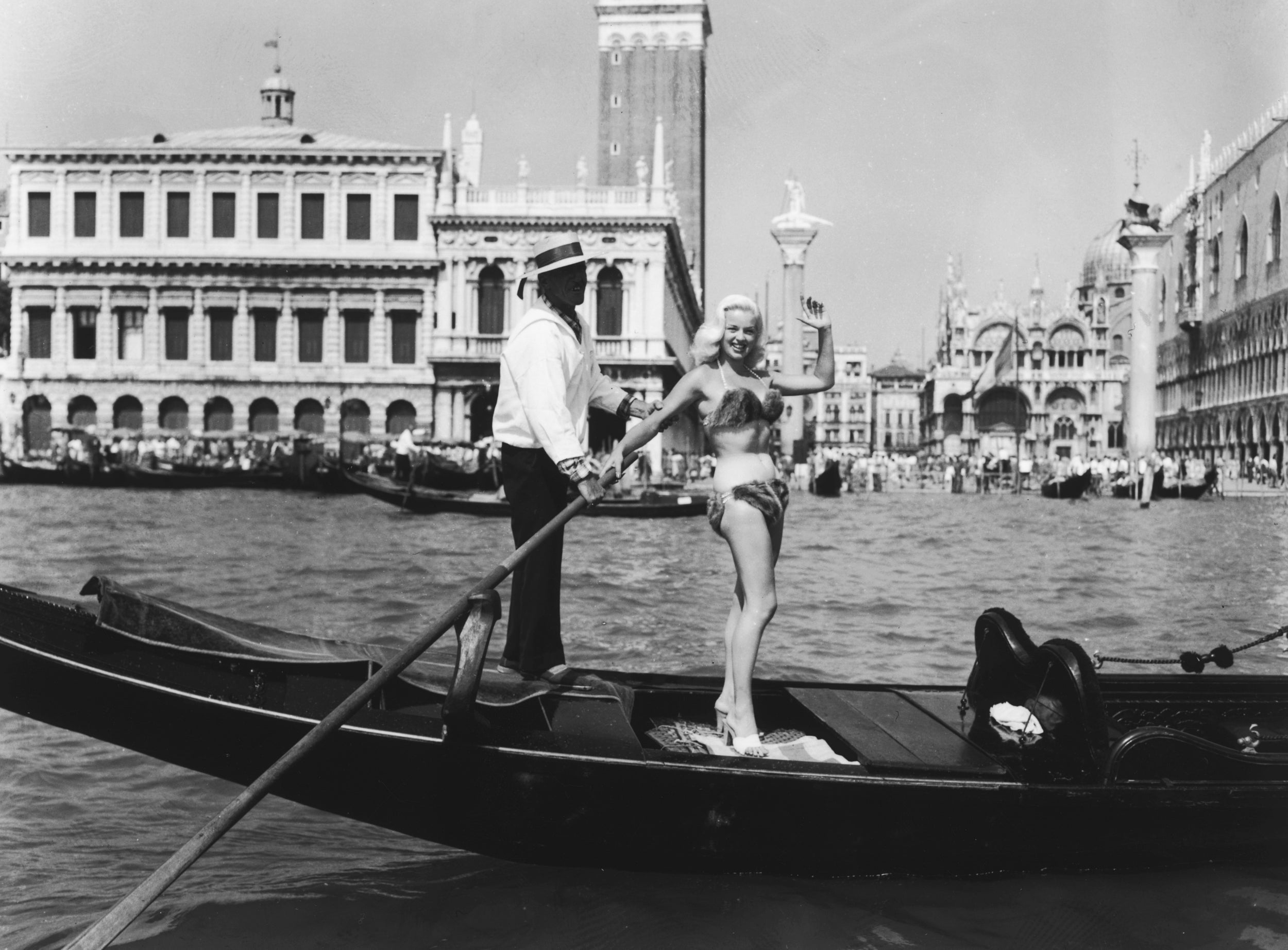 Diana Dors wearing a mink bikini whilst riding in a gondola during the Venice Film Festival in 1955