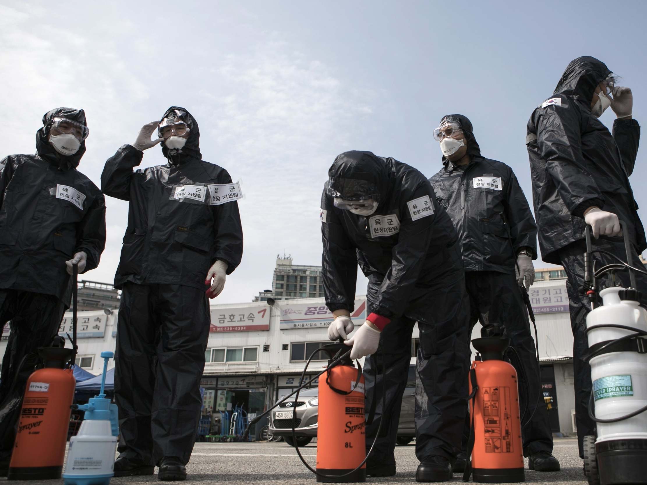 Members of South Korea’s reserve forces wearing protective gear prepare to spray antiseptic solution to guard against coronavirus. The country is testing 20,000 people a day in a huge effort to control the outbreak