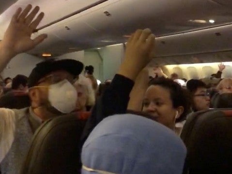 Passengers onboard an airplane from Heathrow Airport London, in mid air, headed to Dallas react to new health regulation announcement concerning Covid-19