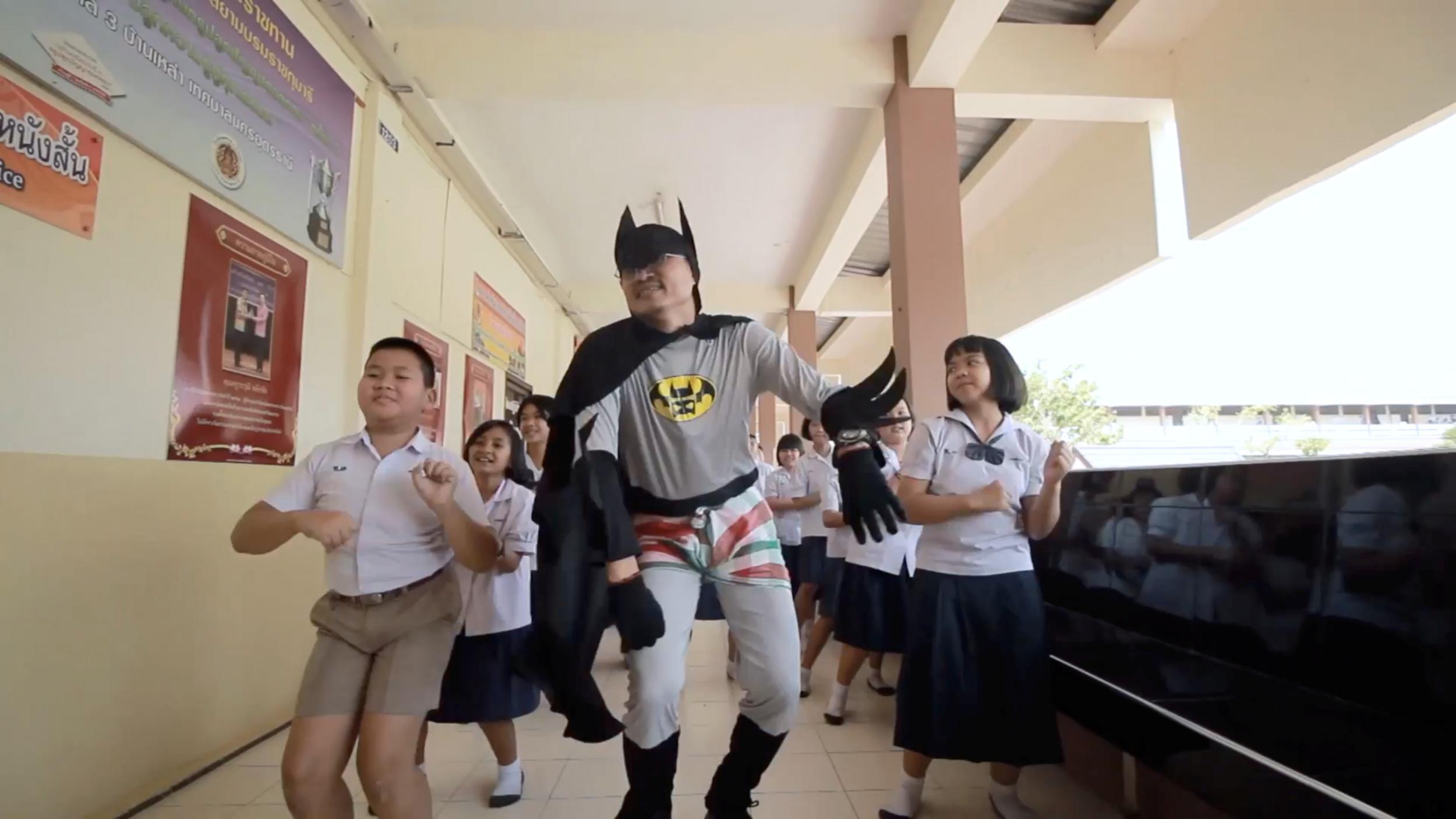 Mr Lakchai runs around with students in the video