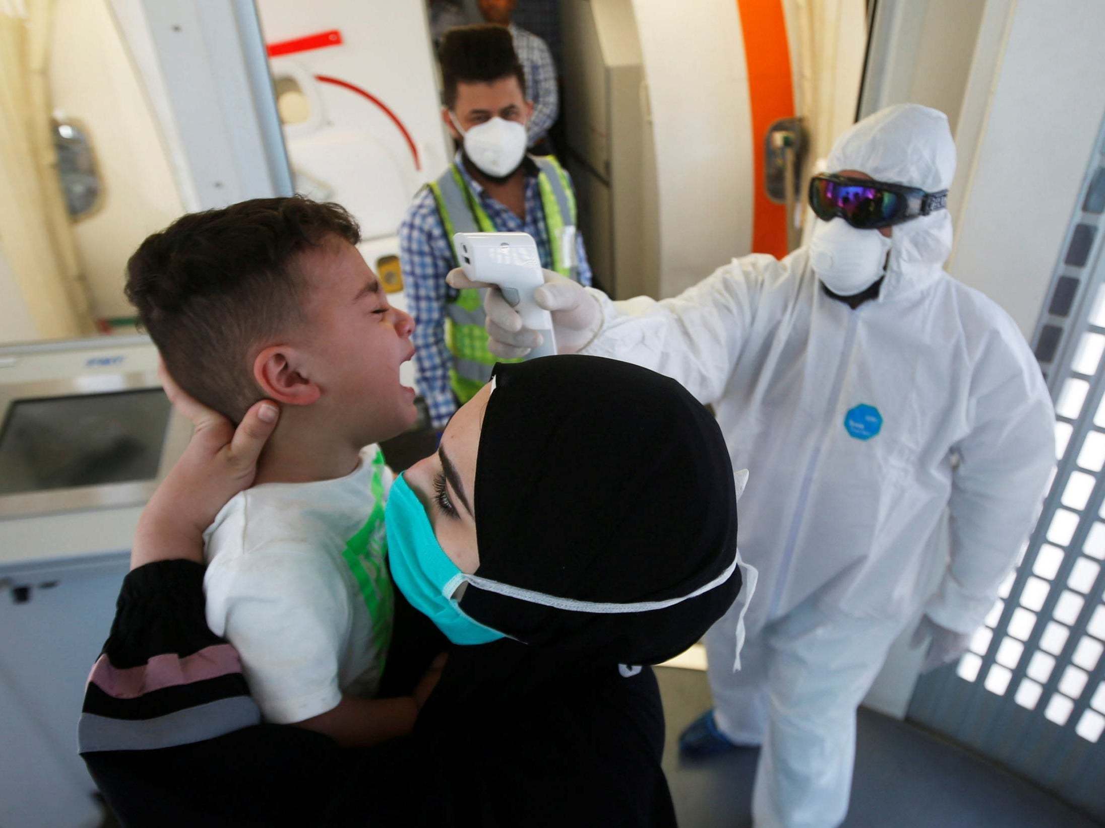 A doctor checks a child’s temperature in Basra, Iraq