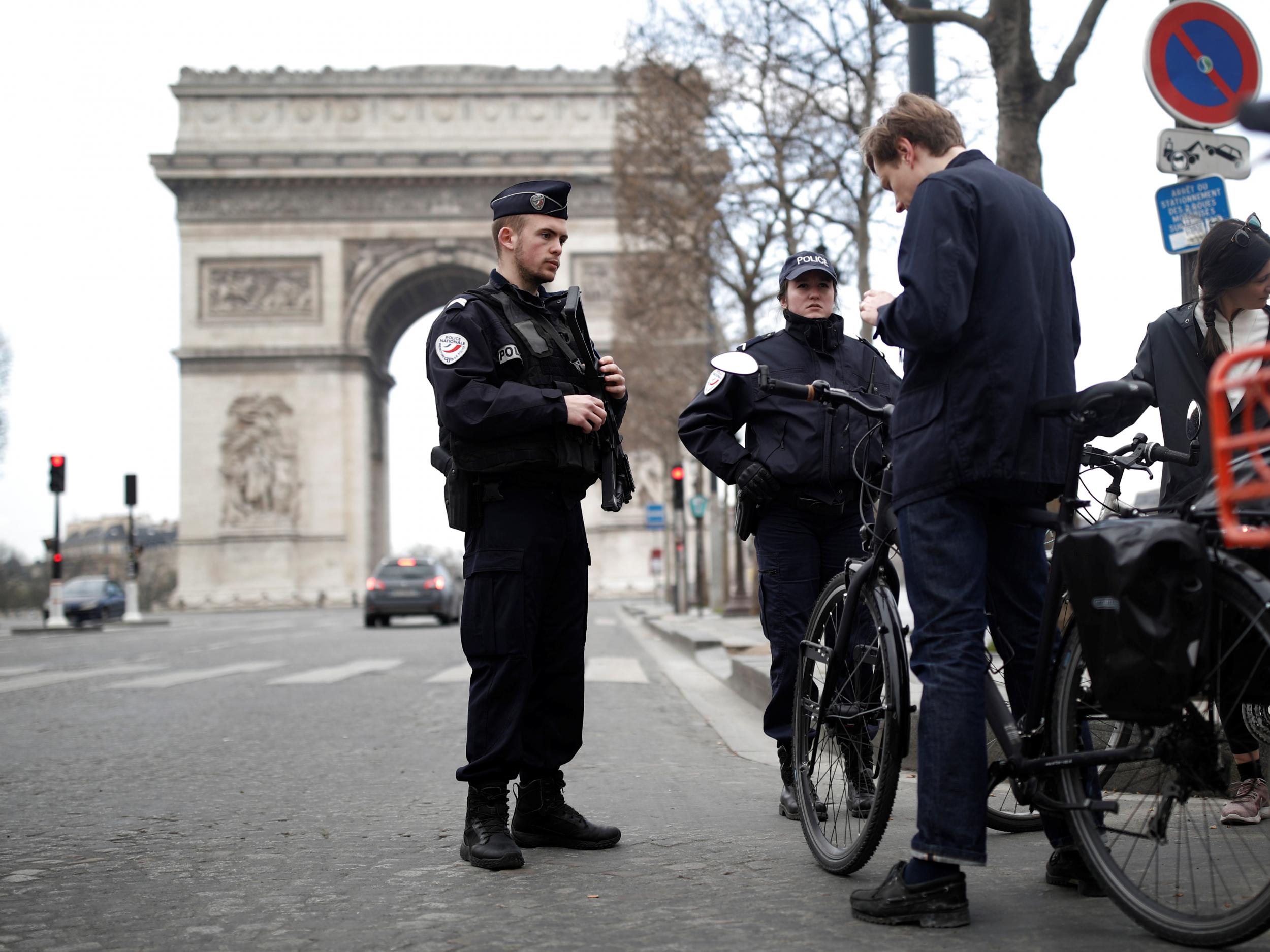 French police officers check cyclists in front of the Arc de Triomphe as lockdown is imposed to slow the spreading of the coronavirus disease (Covid-19) in Paris, France, 18 March, 2020