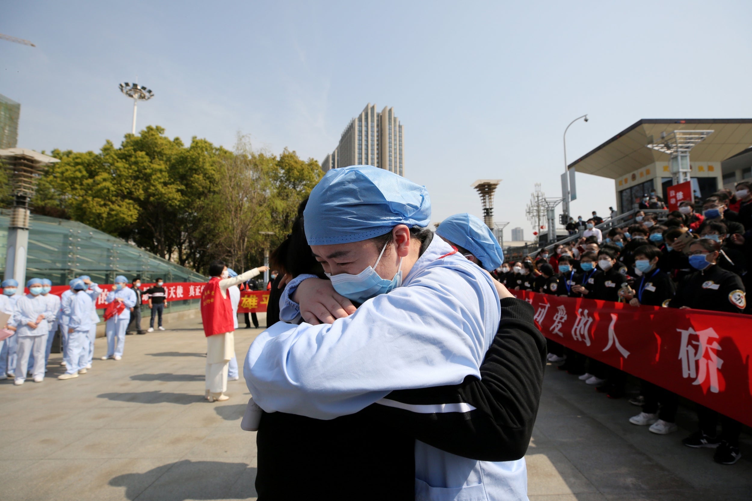 A local medical worker bids farewell to a medical worker from Jiangsu at Wuhan Railway Station, as the medical team from Jiangsu leaves the city