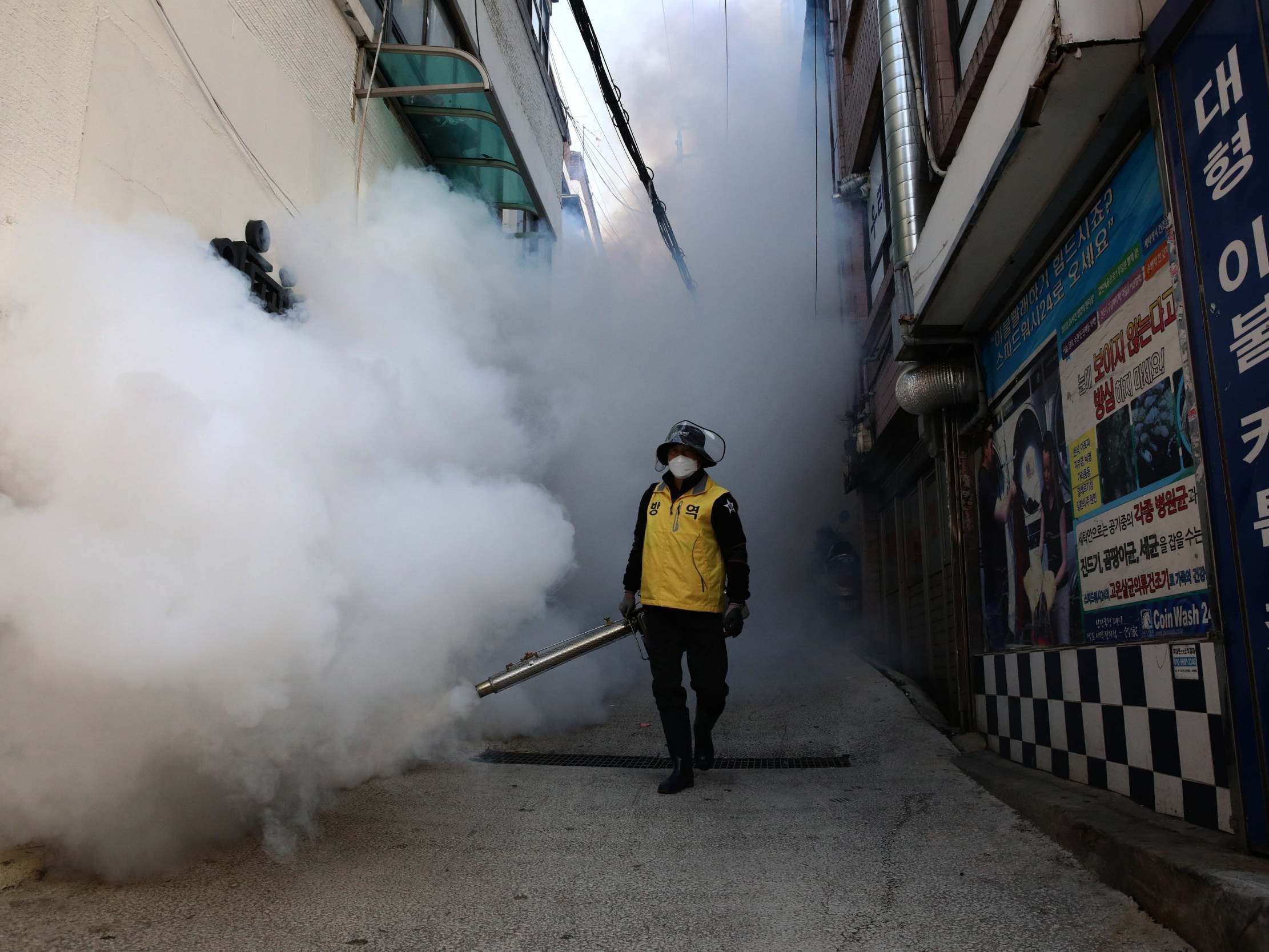 A man disinfects an alley to prevent the spread of coronavirus in Seoul, South Korea