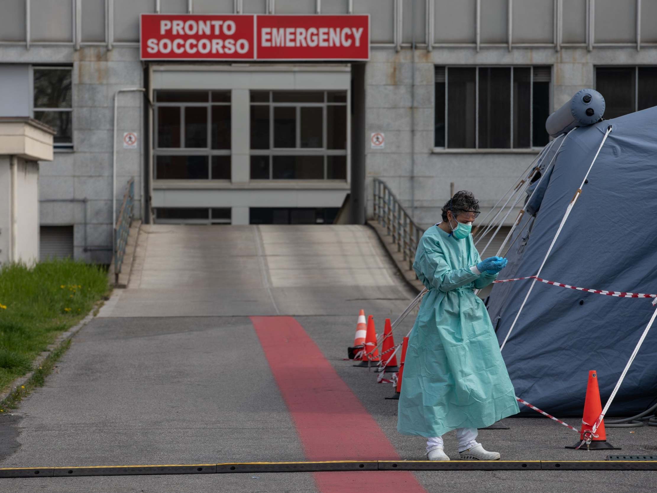 A nurse stands next to a pre-triage tent in front of the A&amp;E department of a local hospital in Cremona, near Milan. Italy's death toll has now surpassed China's