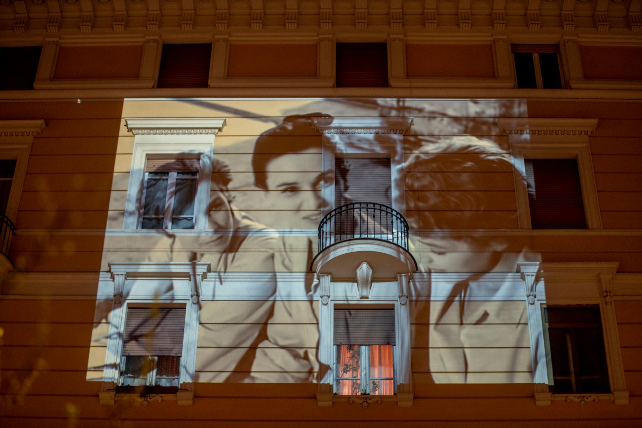 The film <i>Le ragazze di Piazza di Spagna</i> is projected on a building in Rome