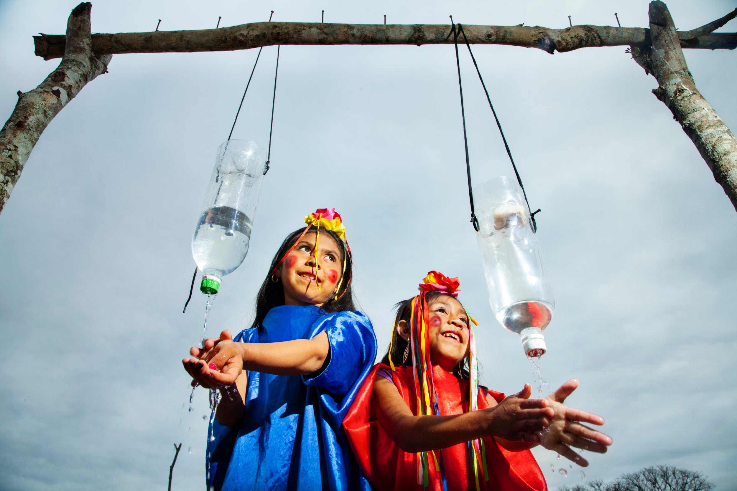 Two girls wash their hands with water from recycled bottles at a rudimentary hand-washing station at La Montana School, Bolivia. Similar hand-washing stations are in use in all schools in areas where water has become scarce