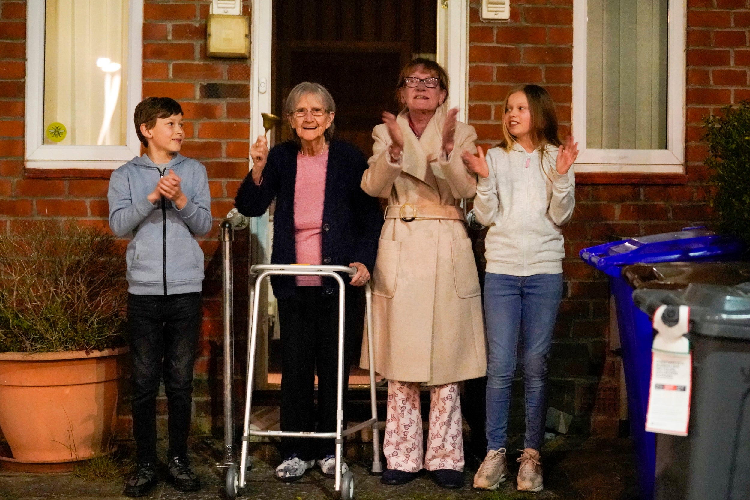 Barbara Leigh, aged 93, (second left) rings a bell for the NHS, with her family who are all staying together throughout the lockdown, from their front garden across the road from Wythenshawe Hospital in Manchester