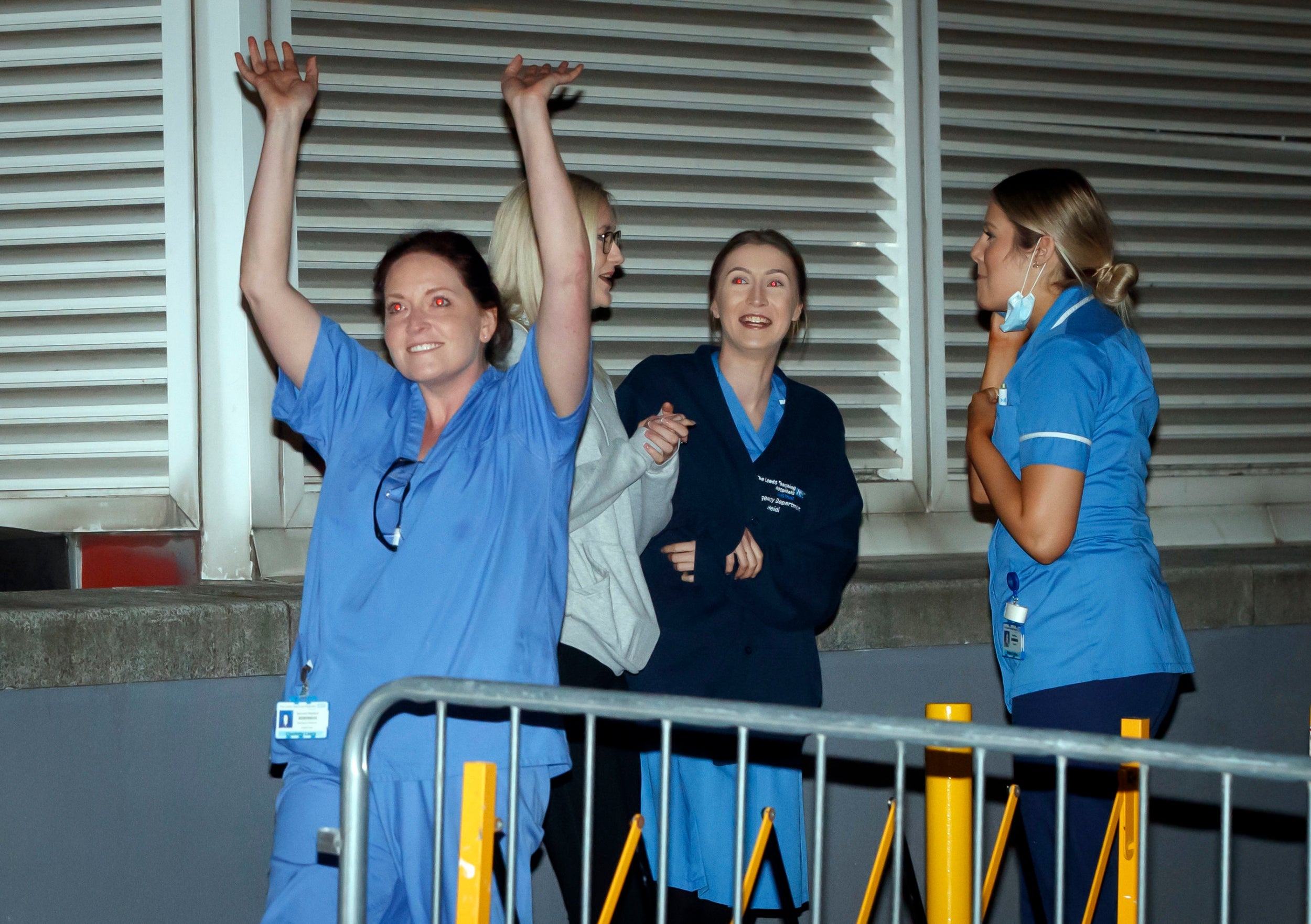 Staff outside the St James's University Hospital in Leeds, wave to people applauding them from their balconies