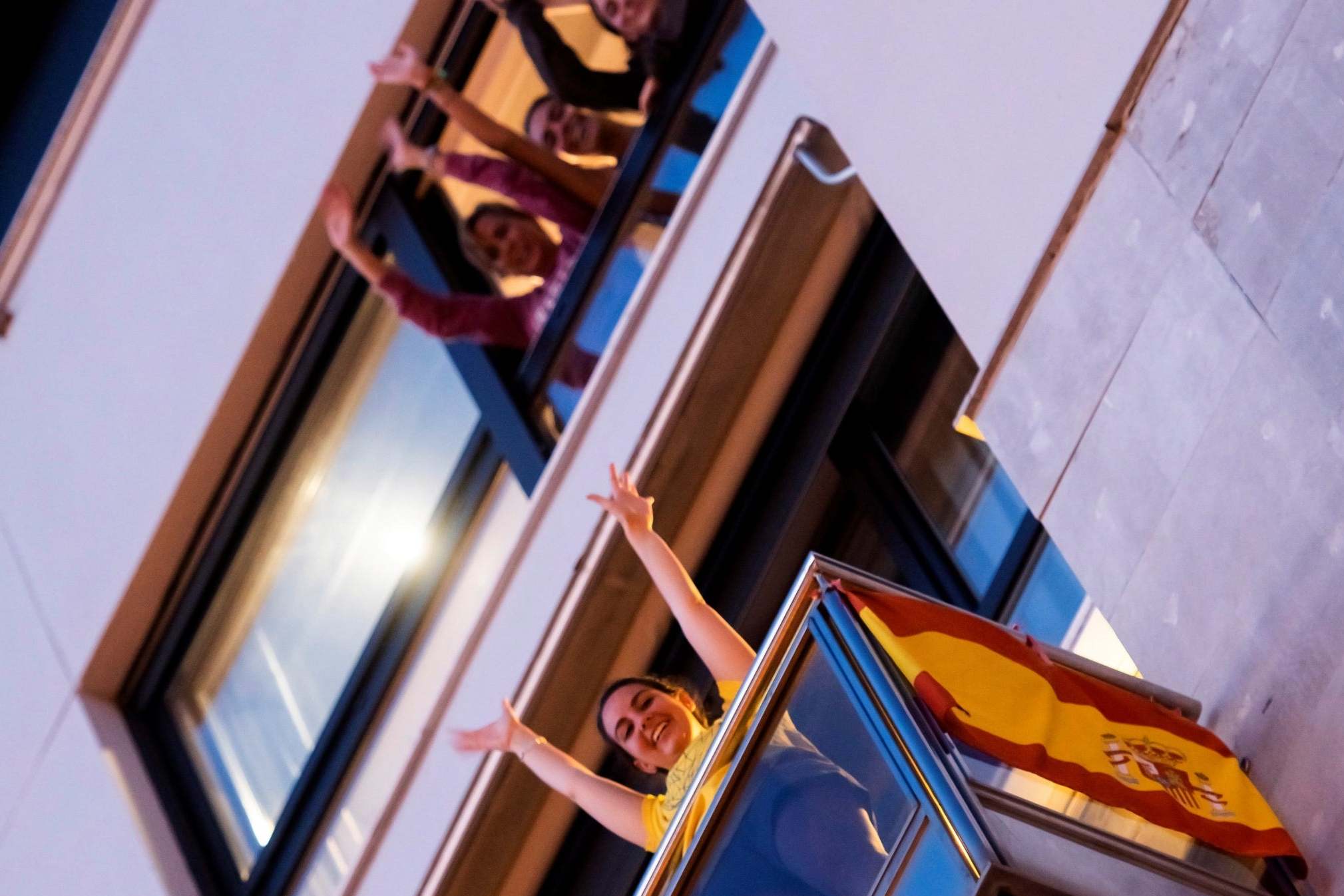 People applaud from their balconies in Seville, Spain