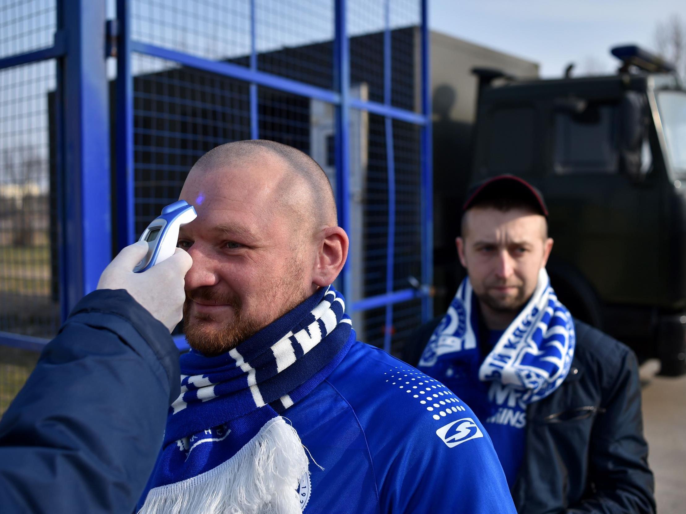 A fan has his temperature checked before entering the stadium