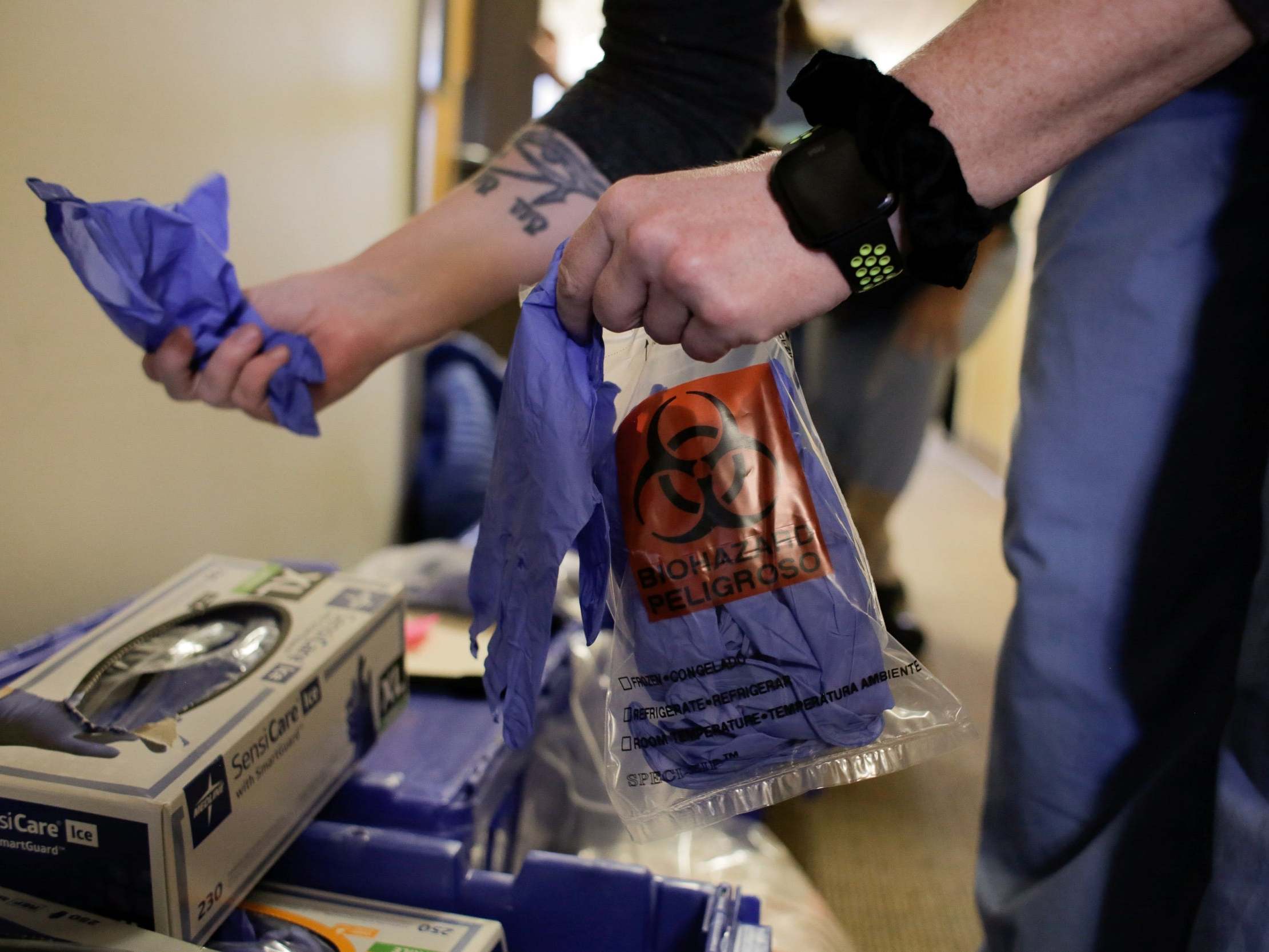 An epidemiologist holds gloves while arranging supplies in a Seattle medical centre