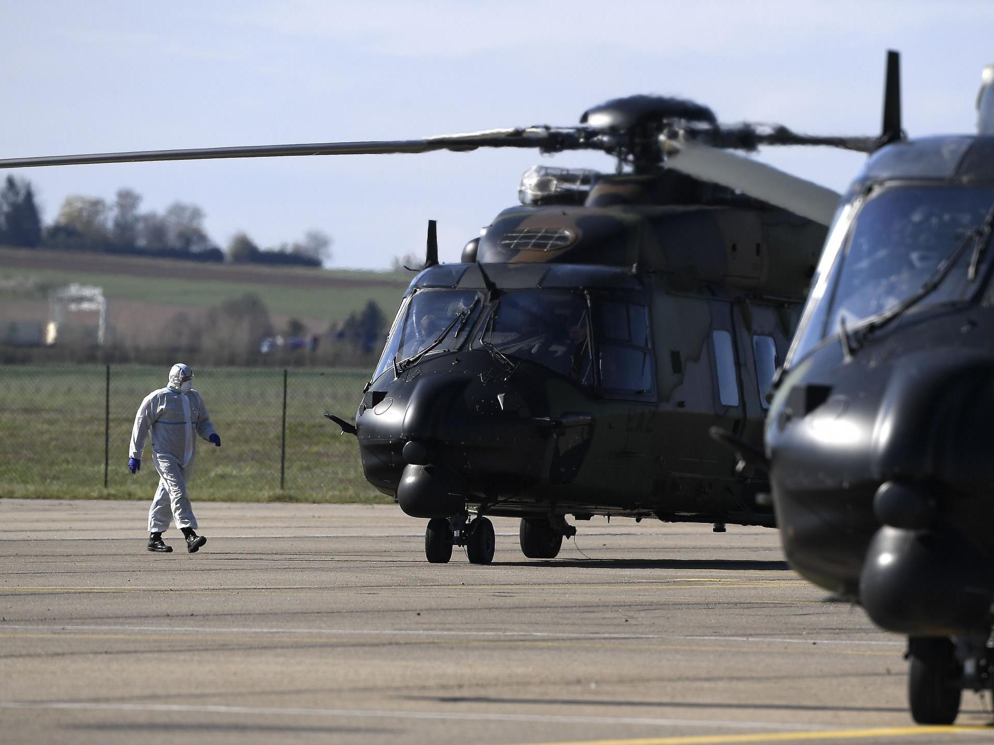 Medical staff wearing protective suit walks as a patient is embarked aboard a French medical helicopter to be evacuated to a German hospital during the coronavirus outbreak