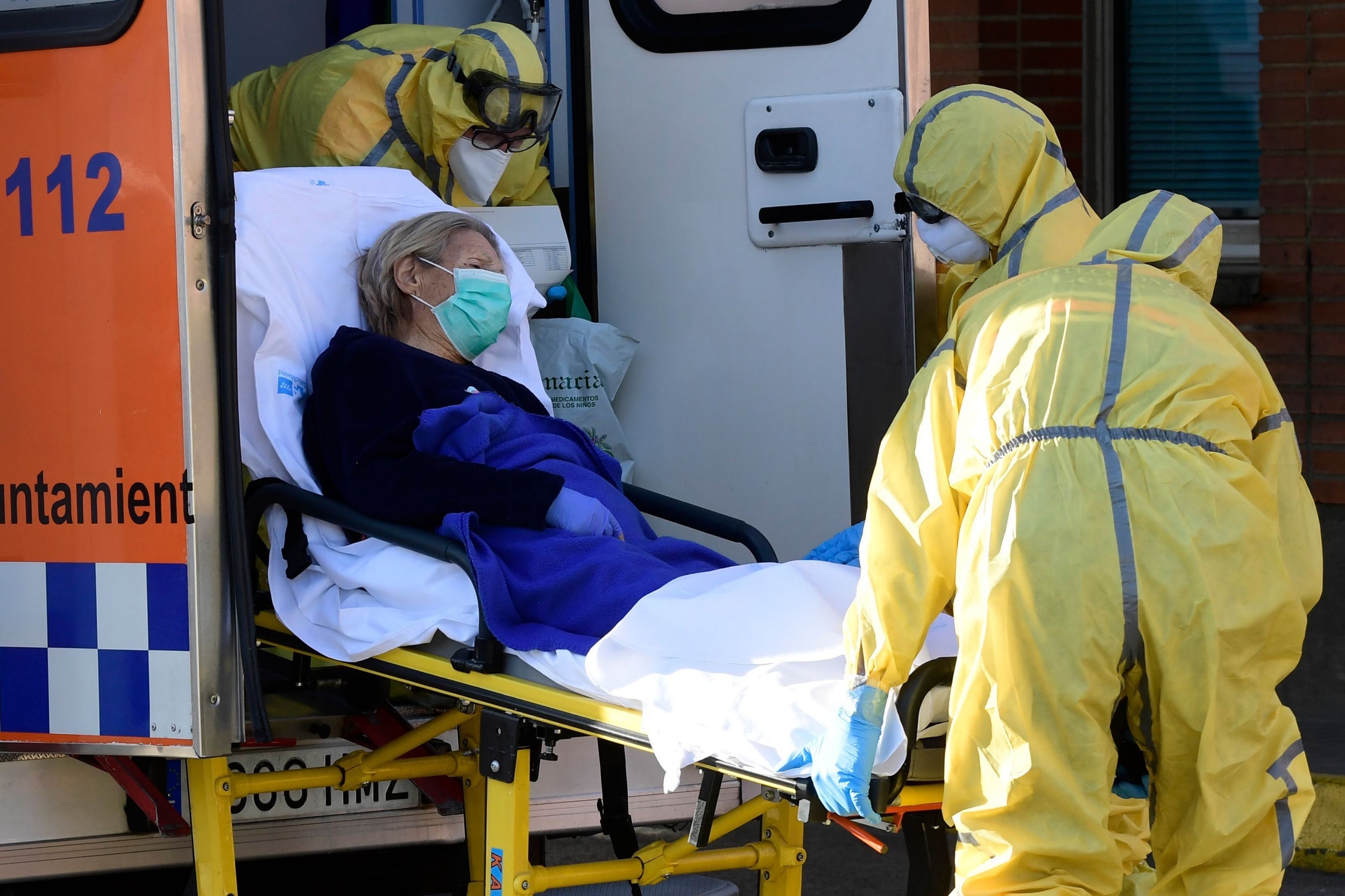 Civil Defence members carry a patient on a stretcher as they arrive at the Severo Ochoa hospital in Leganes, Spain