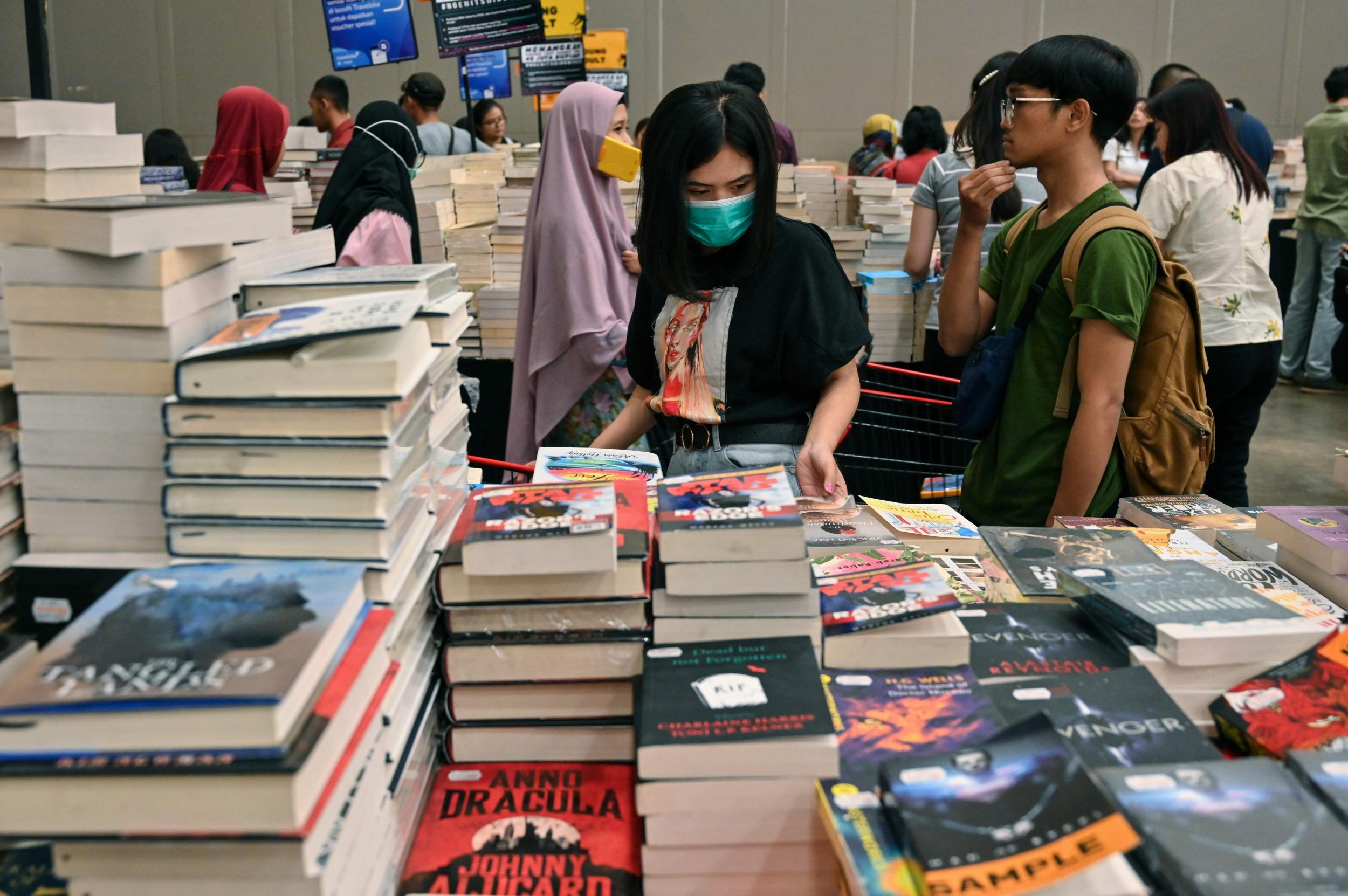 Visitors, wearing a facemasks as a preventive measure against the coronavirus, browse for books during the Big Bad Wolf Books book fair in Jakarta on 8 March 2020.