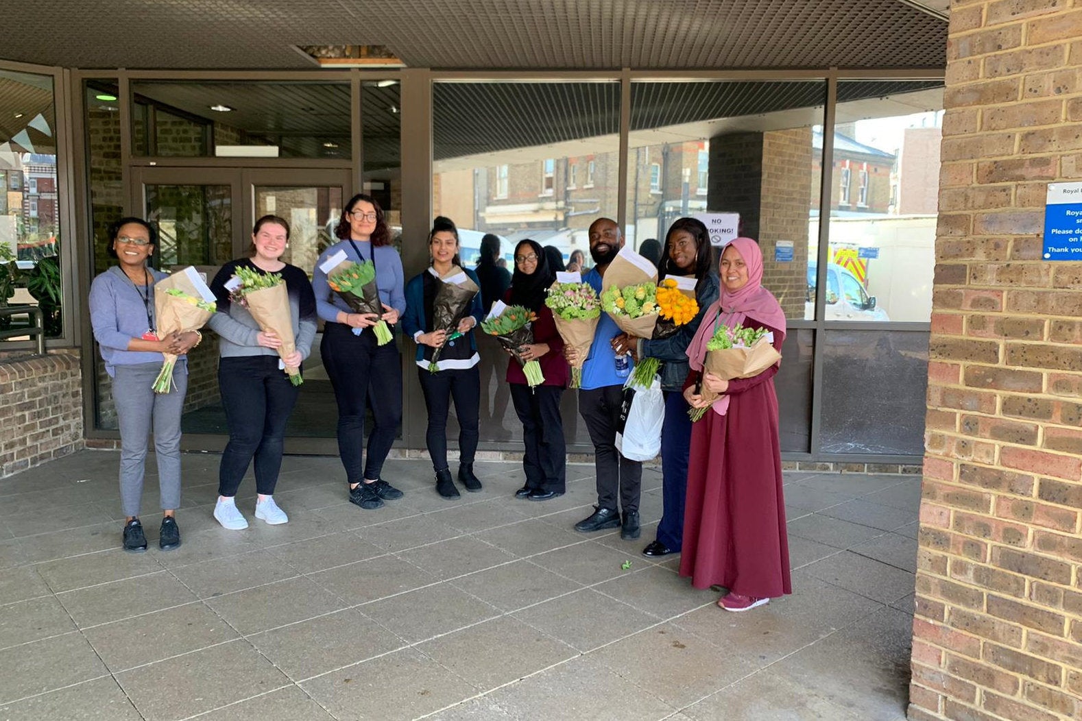 NHS staff smile with their floral bouquets