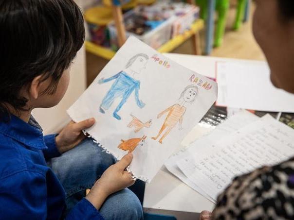 Apollo holds a drawing from his Yemeni penfriend Razan* at home in London (Save The Children)