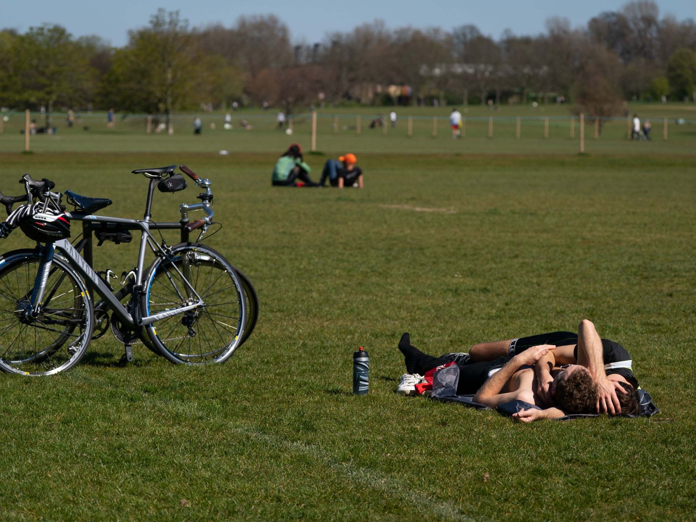 Members of the public relax in the sun in Regents Park, London