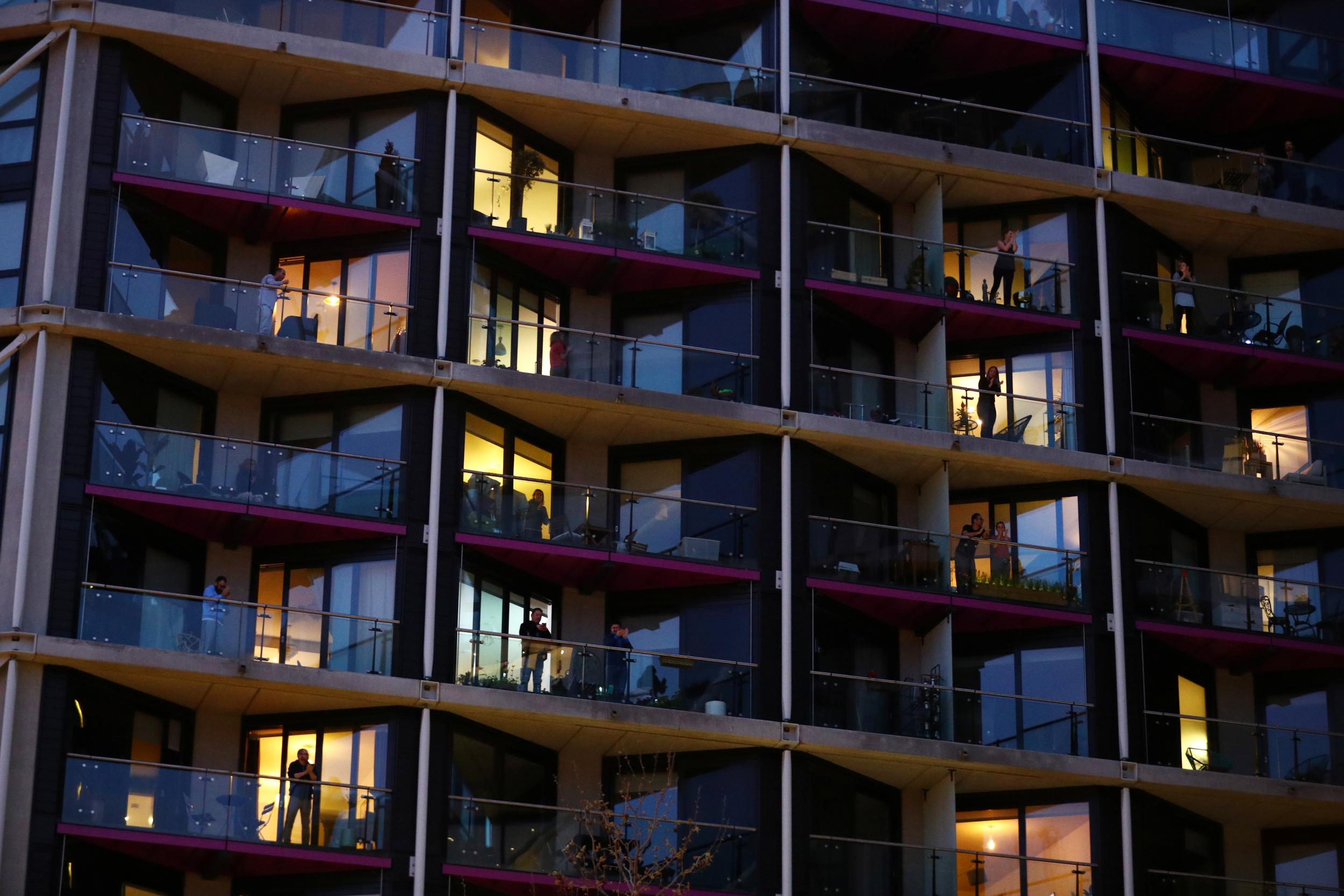 People applaud from flats in London during the Clap for our Carers campaign in support of the NHS