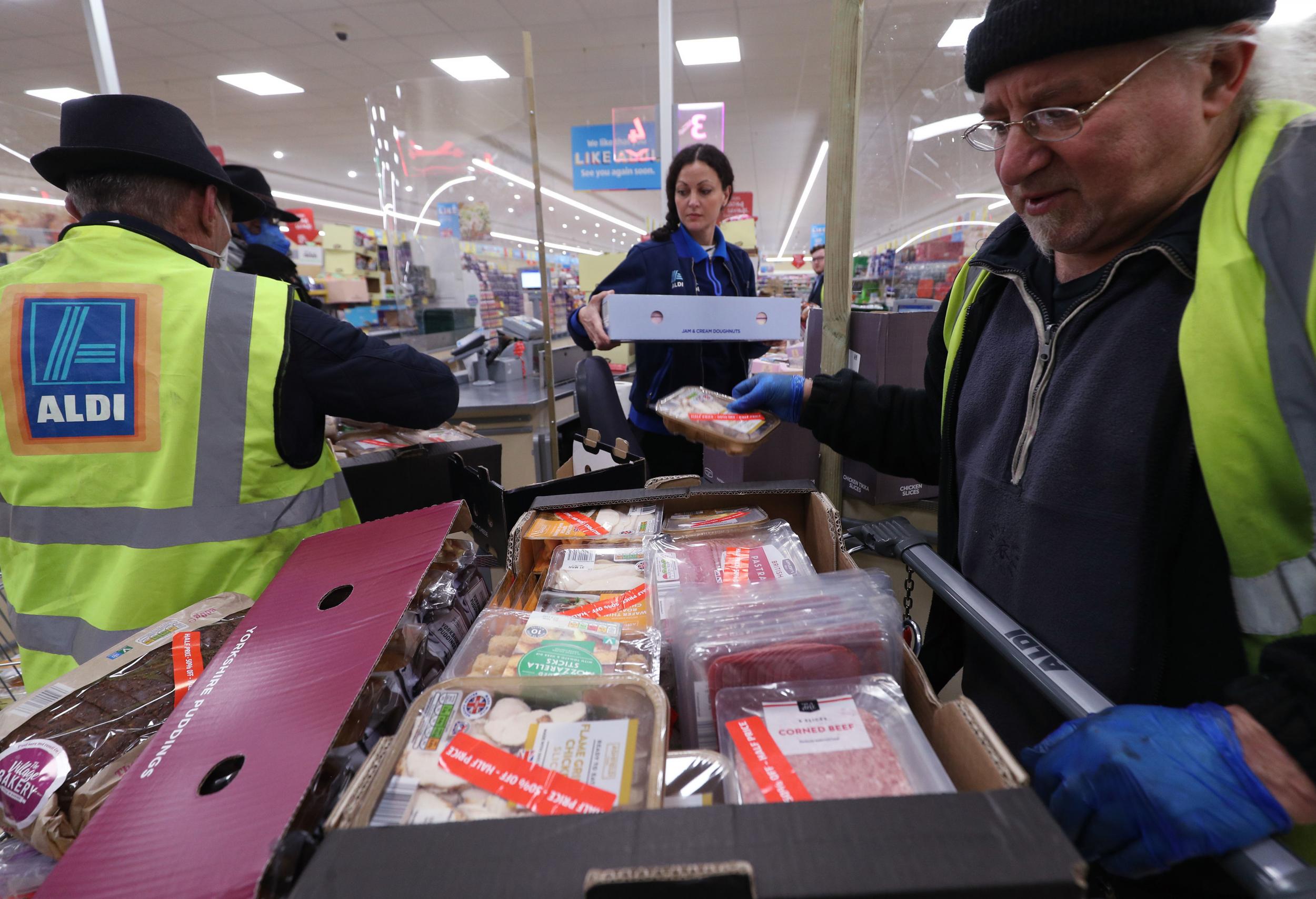 Des Kay (right), the founder of Kingston-based charity Save the World Club, and volunteer Paul Cockle collect surplus food from Aldi in southwest London