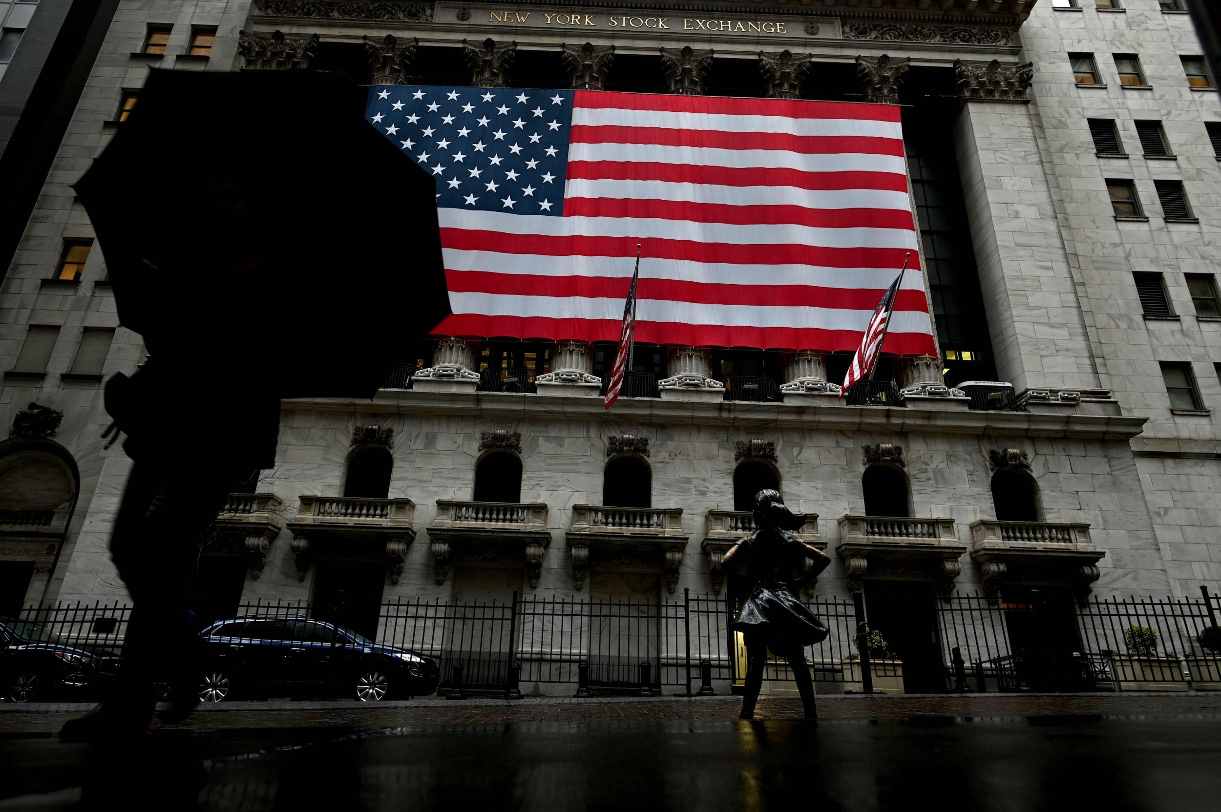 A woman walks past the New York Stock Exchange during the coronavirus pandemic