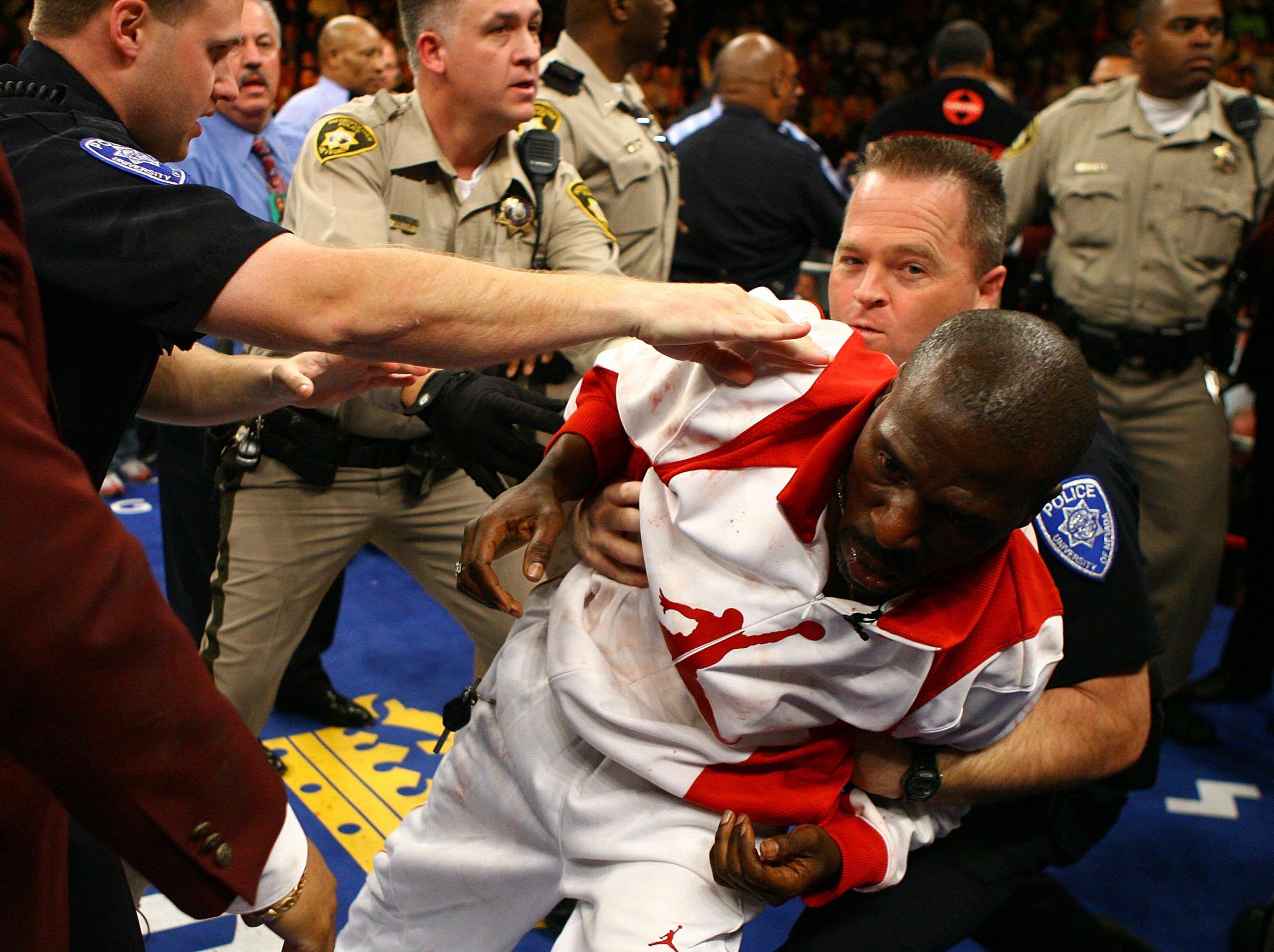 Roger Mayweather is tackled to the canvas in the tenth