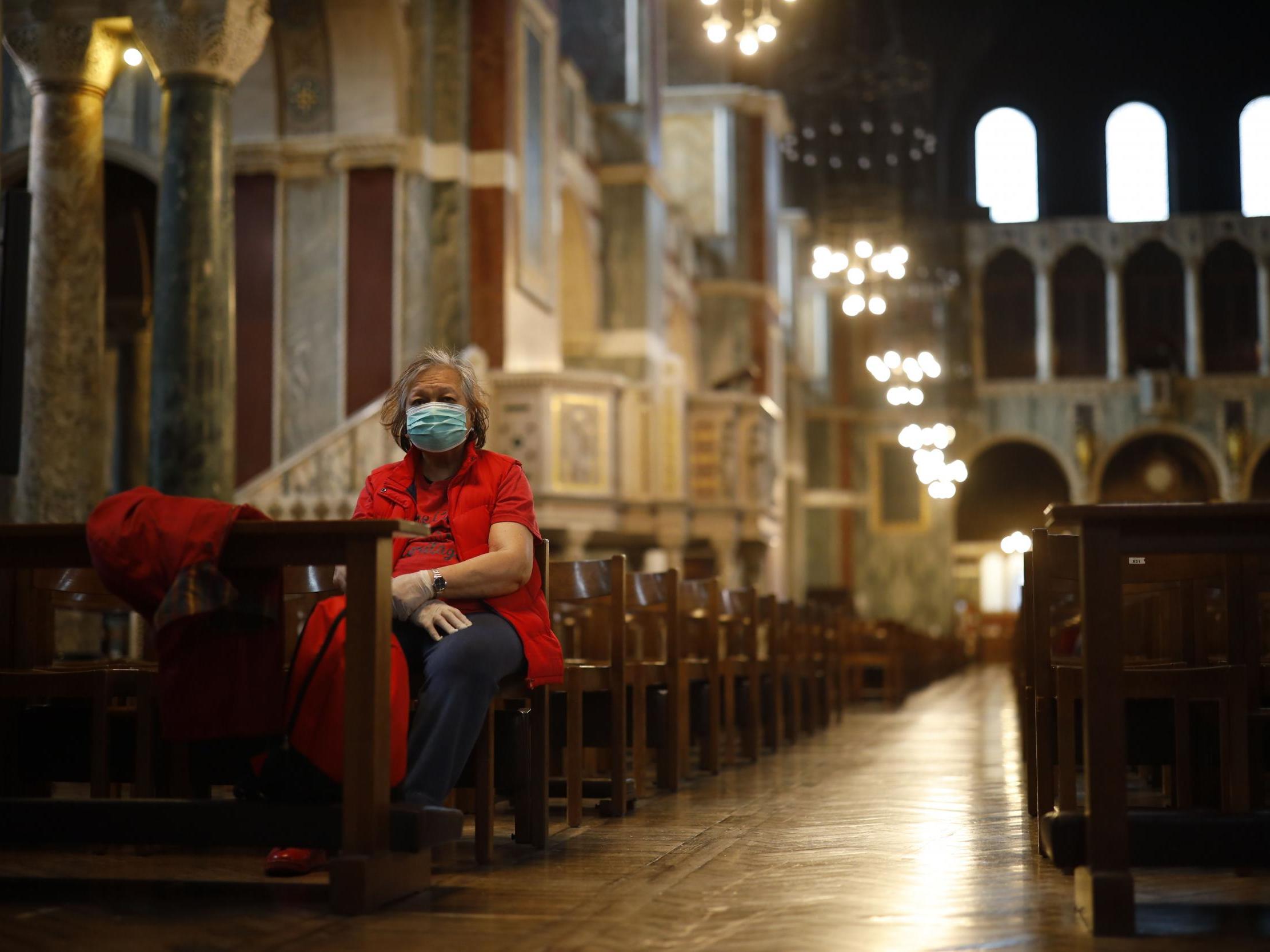 A lone worshipper sits on a pew in Westminster Cathedral