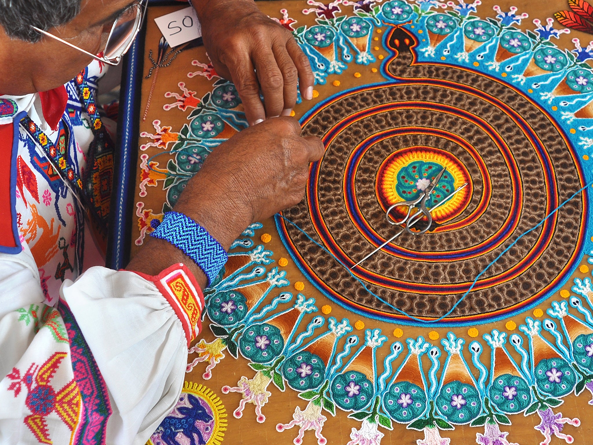 Huichol Indian yarn painter Mariano Navarro demonstrates his art