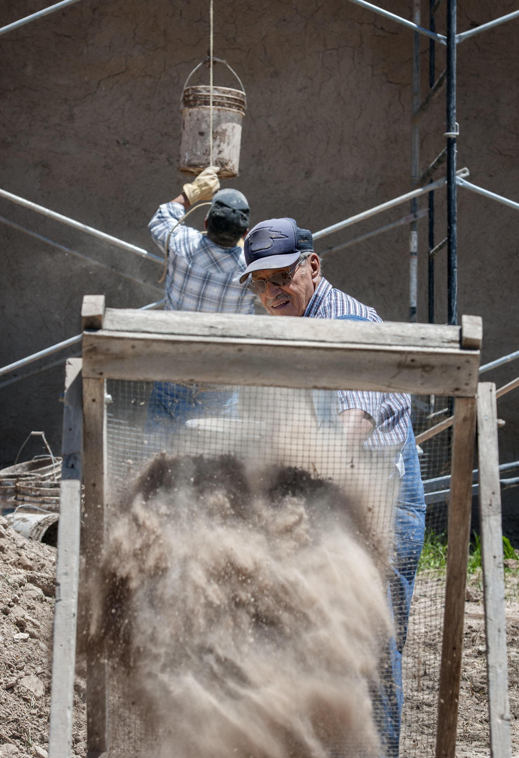 A plasterer works on the walls of the San Jose de la Gracia church in Las Trampas