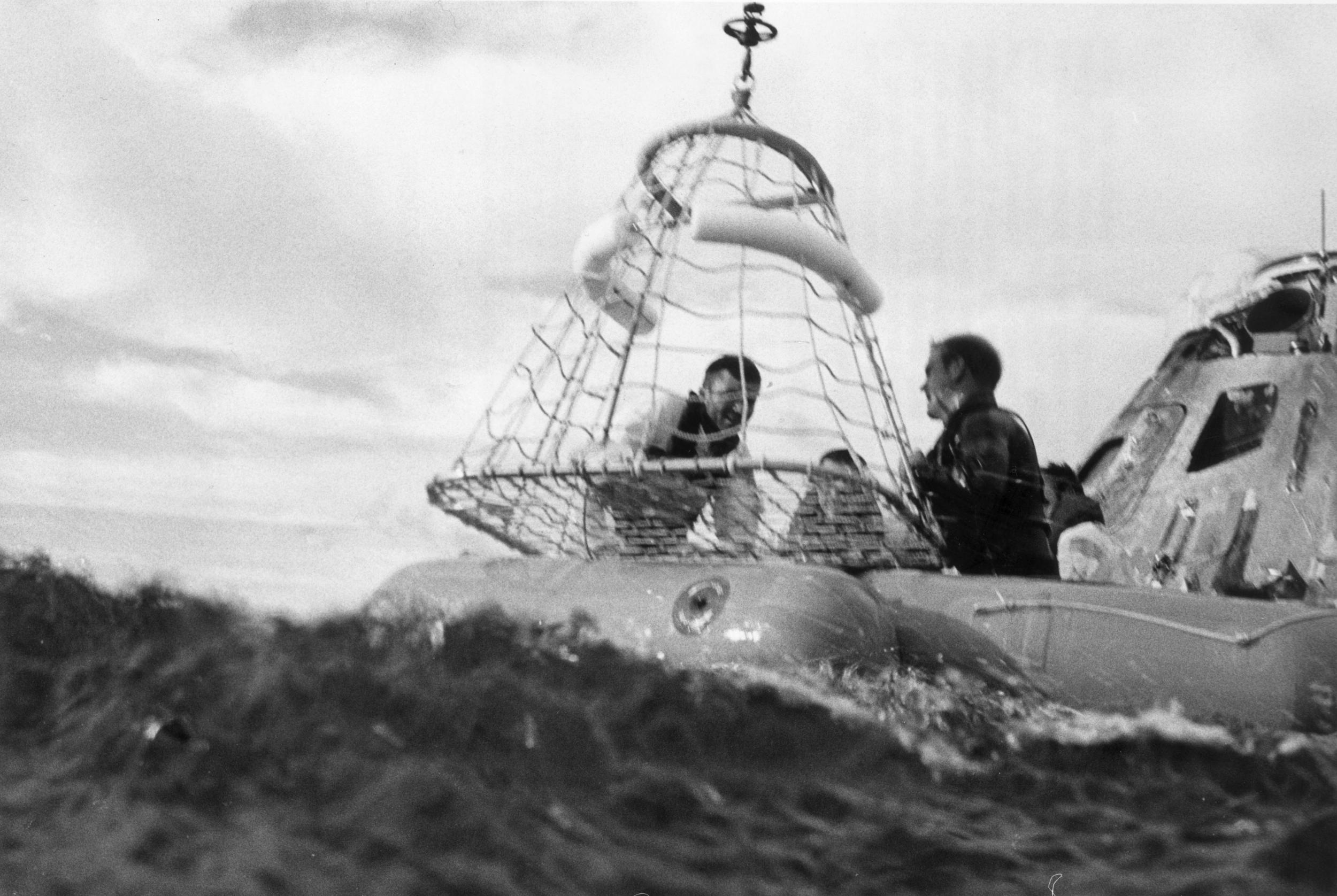 Astronaut and lunar module pilot Fred Haise waits to be hoisted up to a recovery helicopter after landing in the South Pacific