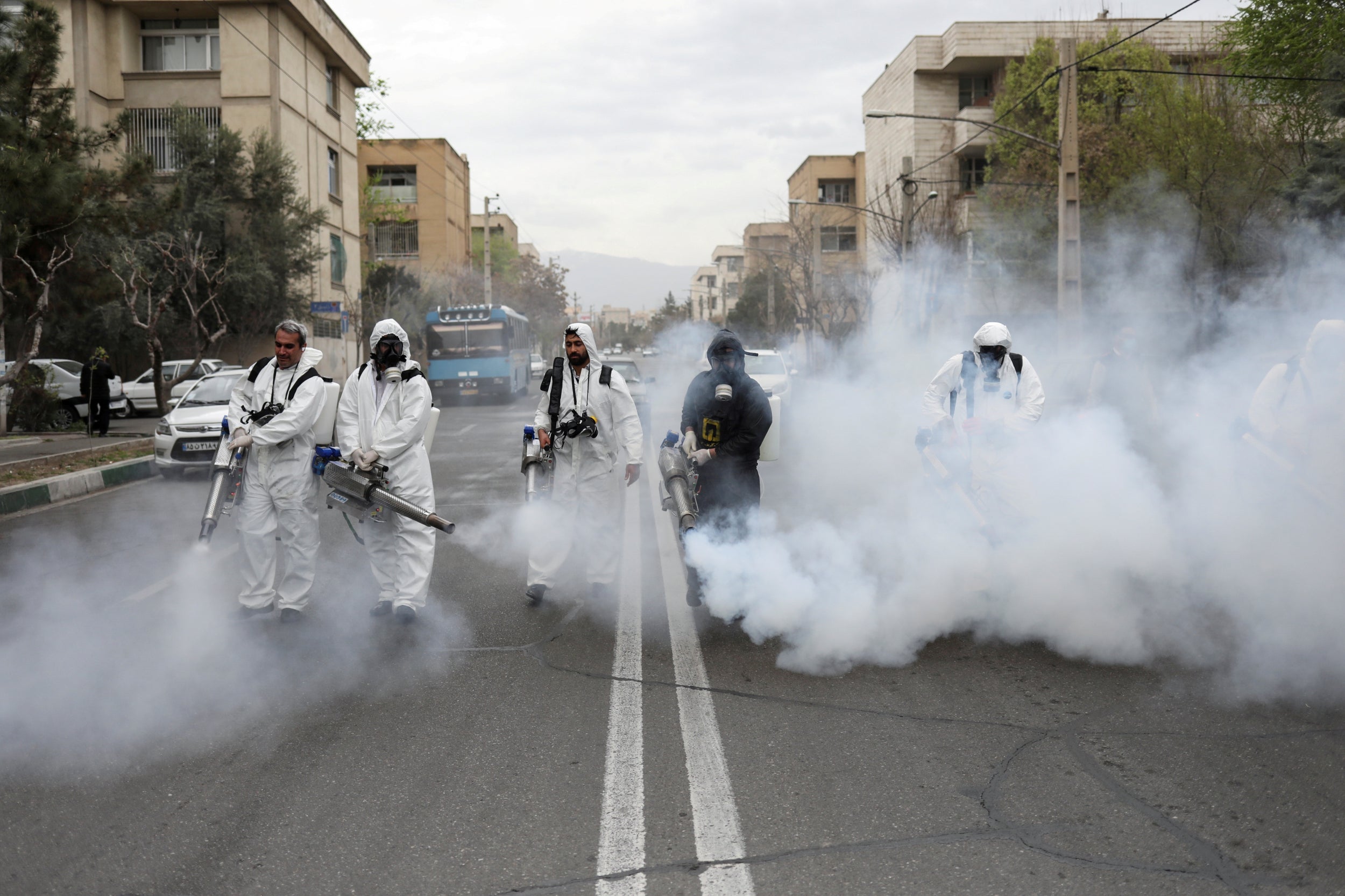 Members of Iran’s firefighters wear protective face masks as they disinfect the streets of Tehran, amid fear of coronavirus disease