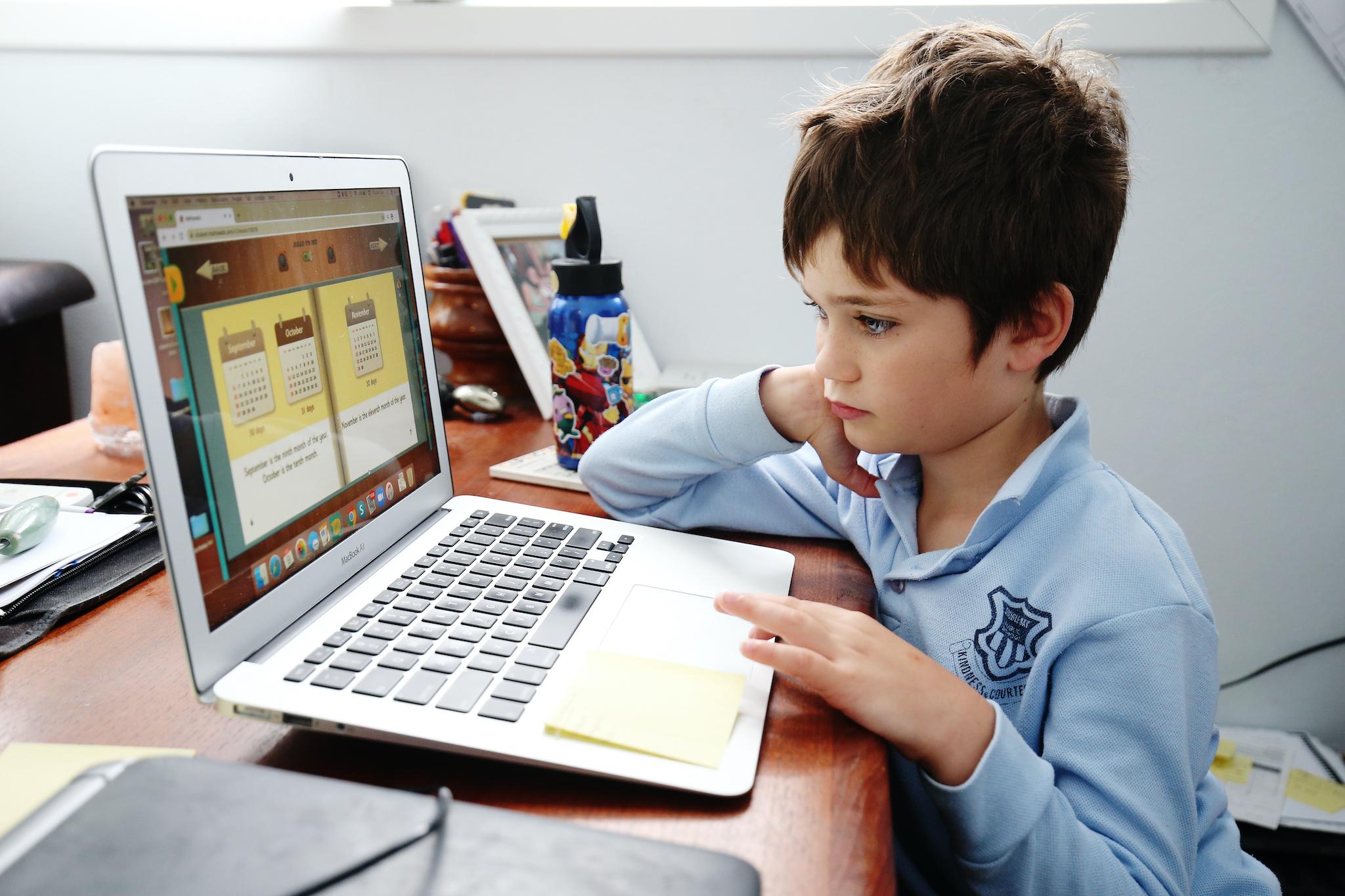 Phoenix Crawford does school work on a laptop while being home-schooled by his mum Donna Eddy on April 09, 2020 in Sydney, Australia