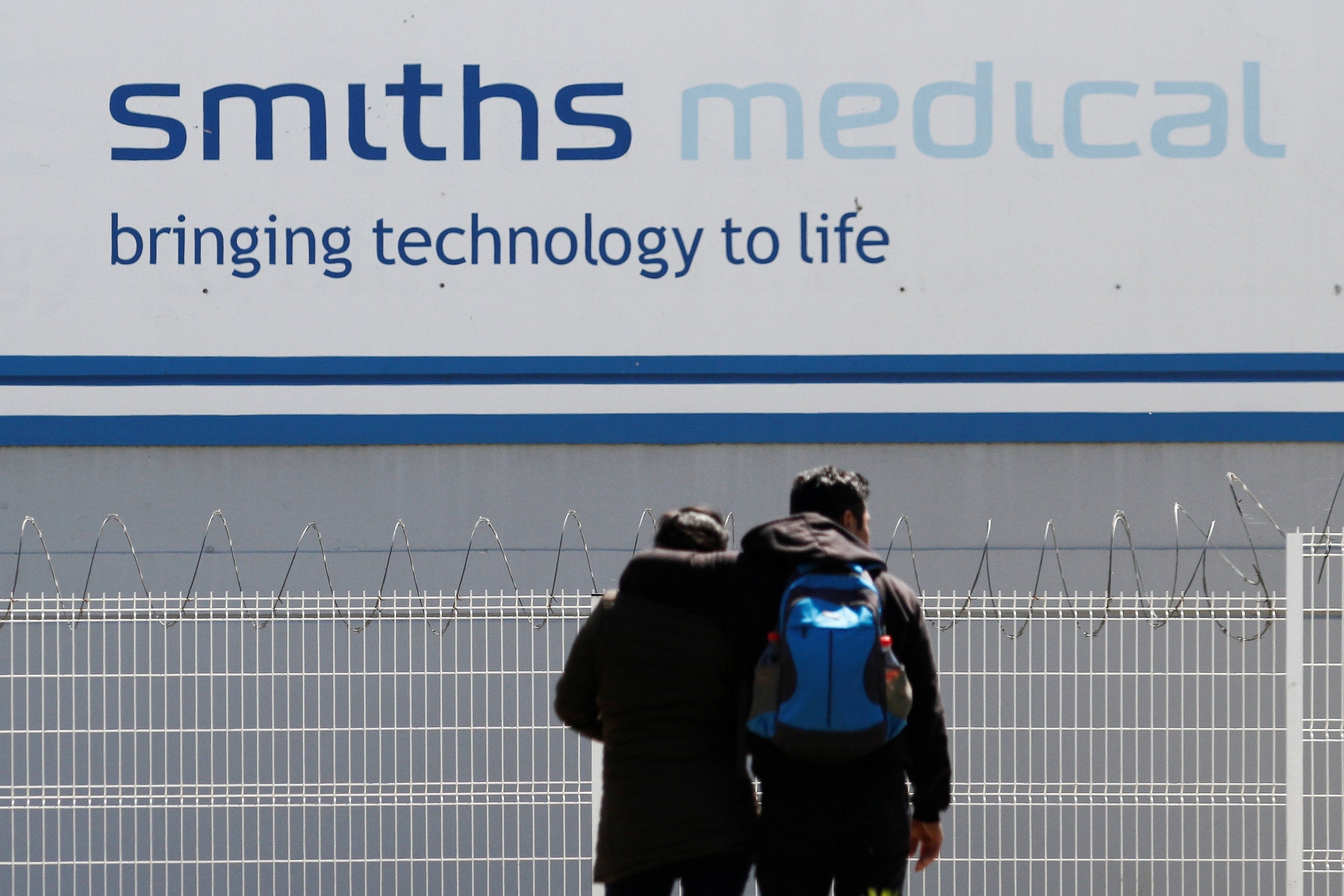 A couple is seen outside Smiths Medical, a global manufacturer of specialty medical devices, in Tijuana, Mexico March 27, 2020. Picture taken March 27, 2020.